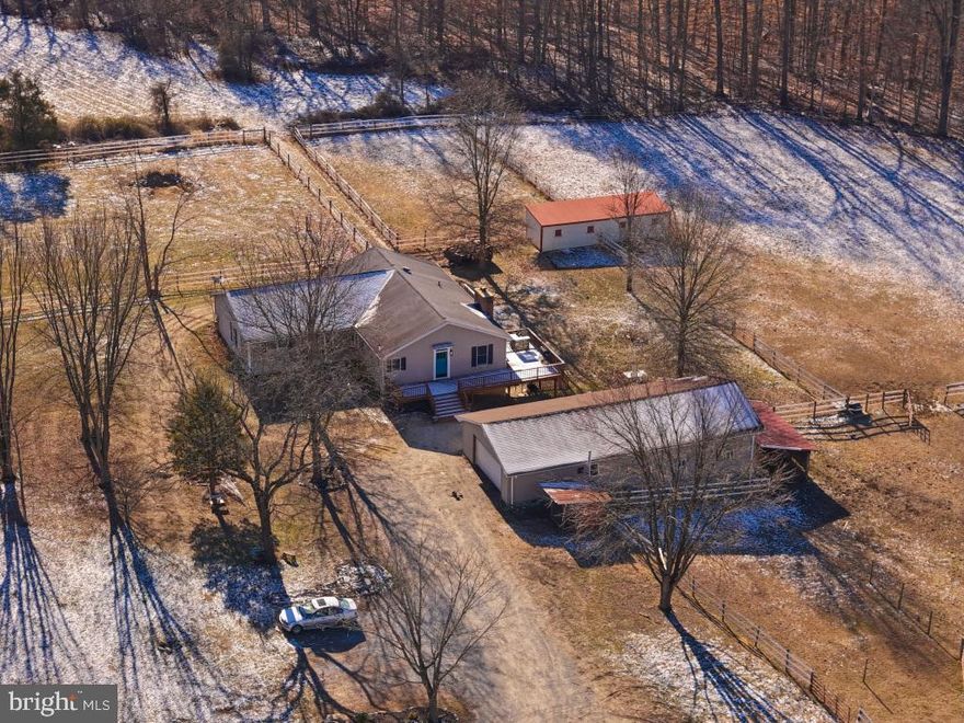 4 BR, 4 BA horse farmette on 9 acres in Darlington, MD. Come check out this property! Large Ranch home with 2,222 sq. ft. on the main level and 2,222 sq. ft. on the lower level with a second full kitchen, full bathroom and walk out with slider doors, totaling 4,444 sq. ft. Enter the front door and step into the stunning large open concept grand room. This space consists of the living room area with elevated ceiling with ceiling pocket lighting and ceiling fans, accented by the brick fireplace with wood stove fireplace insert and mantle, knotty pine kitchen with Kraftmaid cabinets and farmhouse sink, with large island, black appliances including a convection oven. This spectacular space has sliders that open to a deck to view the pastures and the deck even has a custom wood dumb waiter to bring your wood in with ease. The wing off of the living room has a hallway full bath, a primary bedroom and private bath ensuite, and a 2nd full bedroom with a convenient hallway laundry. The second wing of the home includes another primary bedroom and bathroom combo ensuite with another full bedroom. There's an exterior door that provides access to the side covered porch. The downstairs provides a full functioning second kitchen and full bath with walk out sliders. The outside assets include a 2 car garage with dirt floor,  a barn with 4 horse stalls with brushing and tack room with loft. There are four fenced in fields: 1) small field with holding pen 2) riding arena 3)36' x 12' run in shed row barn (amish built) and 4) large 3-4 acre pasture. Schedule your showing today.