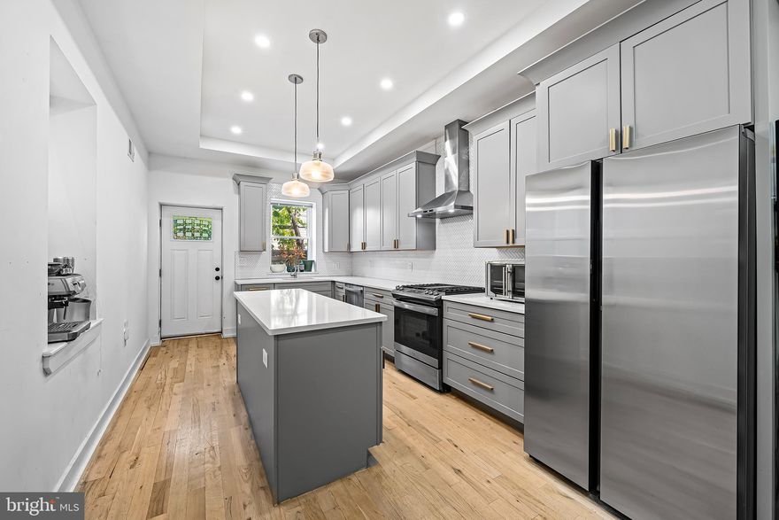 Rehabbed in 2022, this spacious three-bedroom, four-and-a-half-bath home delivers all the comfort, character, and city style you’ve been searching for. Start your mornings on the inviting front porch, and end your days on the rooftop deck with sweeping skyline views—the best spot in the city for fireworks.
Inside, an open floor plan connects the living and dining areas, featuring exposed brick, oak hardwood floors, and modern metal railings. The chef’s kitchen shines with quartz countertops, a large island with built-in microwave, stainless appliances, and a custom herringbone tile backsplash. A half bath and private fenced patio complete the main level.
Upstairs, two inviting bedrooms offer plenty of comfort. The rear bedroom is calm and quiet with access to the hall bath and its tiled tub/shower combo, while the front bedroom features a sunlit bay window, walk-in closet, and spa-like en suite. Laundry is conveniently tucked into a hall closet.
The third-floor primary suite is your private escape—complete with an exposed brick accent wall, spacious walk-in closet, and sleek en suite bath with frameless glass shower.
A finished basement adds even more flexibility with a full bath, tiled ceilings, and an added door for privacy—perfect for guests, a gym, or media room.
With dual-zoned HVAC, every bedroom boasting its own bath, and a prime location near Fairmount Park and Center City, this home is spacious, move-in ready, and full of personality. Your next chapter starts here.