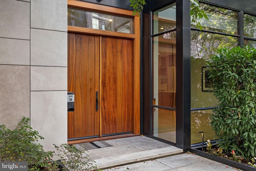 Tucked within a private, landscaped courtyard, this custom residence was thoughtfully designed and built as part of a limited collection of architect-driven townhomes.

Behind its minimalist façade lies a level of craftsmanship rarely seen in contemporary construction: solid-wood doors, architectural steelwork, and oversized windows positioned to frame greenery and the sky.
Standing 25-foot-wide, this home spans more than 5,000 square feet across five levels of refined living and includes four bedrooms, four full baths, two half baths, an elevator serving all floors, and 2-car garage parking. The home combines scale, elegance, and ease in one of Philadelphia’s most desirable neighborhoods.

The entry level opens to a welcoming foyer that leads into a light-filled living, dining, and kitchen space, designed for both daily comfort and entertaining. Anchored by an oversized island, the kitchen features quartz countertops, custom cabinetry, a walk-in pantry with a coffee bar, and premium appliances. The dining area easily accommodates large gatherings, while the living room connects to a private patio via glass sliders, complete with an outdoor kitchen—featuring a built-in grill and wood-burning pizza oven—for effortless indoor/outdoor living.

The second level offers an expansive family room with a sleek media wall and gas fireplace, along with a guest suite featuring an en-suite bath. The third level is dedicated to the primary suite, with a gracious bedroom, custom walk-in wardrobe, and a spa-inspired bath with soaking tub, double marble vanity, glass shower, and heated tile floors. The fourth floor is defined by a dramatic double-height lounge, flanked by two additional bedroom suites and a full laundry room.

The fifth level is designed for entertaining, featuring a kitchenette with refrigeration, ice maker, and sink, plus glass doors that open to a skyline-view roof terrace with fire pit and powder room. The lower level provides direct garage access, a mudroom with built-ins, a large storage/flex space, and abundant closet storage.

Additional highlights include two-zone HVAC, tax abatement, and HOA services that cover landscaping, snow removal, a heated driveway, private trash collection twice weekly, and on-site property management.

Ideally located in the heart of Fitler Square, the home is steps from beloved neighborhood dining (Ambrosia, Sally, Trattoria Carina), cafés (Rabbit, Good Karma, Bacchus), and the green spaces of Fitler Square Park and Schuylkill River Park with its trails, dog runs, and sport courts. It offers quick access to Penn, CHOP, Drexel, 30th Street Station, the airport, and is within the Greenfield School catchment.