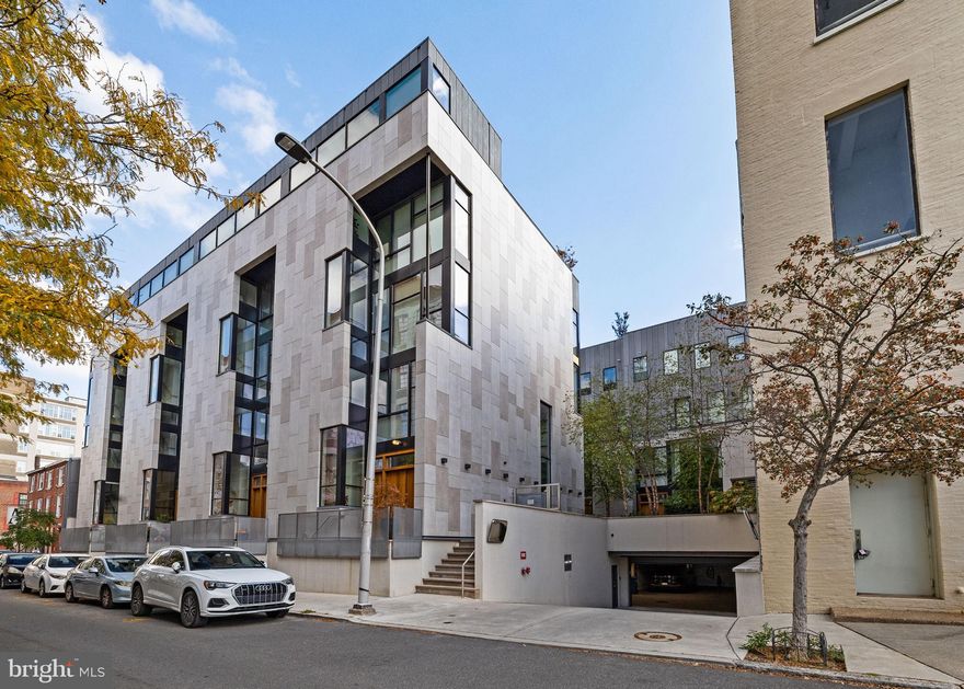 Tucked within a private, landscaped courtyard, this custom residence was thoughtfully designed and built as part of a limited collection of architect-driven townhomes. 

Behind its minimalist façade lies a level of craftsmanship rarely seen in contemporary construction: solid-wood doors, architectural steelwork, and oversized windows positioned to frame greenery and the sky.
Standing 25-foot-wide, this home spans more than 5,000 square feet across five levels of refined living and includes four bedrooms, four full baths, two half baths, an elevator serving all floors, and 2-car garage parking. The home combines scale, elegance, and ease in one of Philadelphia’s most desirable neighborhoods.

The entry level opens to a welcoming foyer that leads into a light-filled living, dining, and kitchen space, designed for both daily comfort and entertaining. Anchored by an oversized island, the kitchen features quartz countertops, custom cabinetry, a walk-in pantry with a coffee bar, and premium appliances. The dining area easily accommodates large gatherings, while the living room connects to a private patio via glass sliders, complete with an outdoor kitchen—featuring a built-in grill and wood-burning pizza oven—for effortless indoor/outdoor living.

The second level offers an expansive family room with a sleek media wall and gas fireplace, along with a guest suite featuring an en-suite bath. The third level is dedicated to the primary suite, with a gracious bedroom, custom walk-in wardrobe, and a spa-inspired bath with soaking tub, double marble vanity, glass shower, and heated tile floors. The fourth floor is defined by a dramatic double-height lounge, flanked by two additional bedroom suites and a full laundry room.

The fifth level is designed for entertaining, featuring a kitchenette with refrigeration, ice maker, and sink, plus glass doors that open to a skyline-view roof terrace with fire pit and powder room. The lower level provides direct garage access, a mudroom with built-ins, a large storage/flex space, and abundant closet storage.

Additional highlights include two-zone HVAC, tax abatement, and HOA services that cover landscaping, snow removal, a heated driveway, private trash collection twice weekly, and on-site property management.

Ideally located in the heart of Fitler Square, the home is steps from beloved neighborhood dining (Ambrosia, Sally, Trattoria Carina), cafés (Rabbit, Good Karma, Bacchus), and the green spaces of Fitler Square Park and Schuylkill River Park with its trails, dog runs, and sport courts. It offers quick access to Penn, CHOP, Drexel, 30th Street Station, the airport, and is within the Greenfield School catchment.