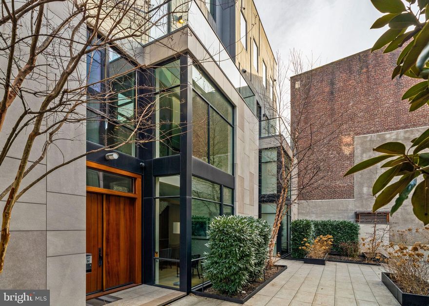 In the esteemed Fitler 9 development, House H is tucked off the street in the secured, landscaped courtyard, offering privacy and tranquility from the street. Completed in 2018, this custom-designed townhouse is 25 ft wide, spanning 5,000+ SF across five levels of living, offering four bedrooms, four full bathrooms, two half baths, an elevator to all levels, 2-car garage parking, a patio, and a roof terrace. Enter through a welcoming foyer into the open kitchen, dining & living area. With its oversized island, the kitchen sits in the center of this level, offering an ideal flow for entertaining and everyday living. The kitchen has high-end appliances, quartz counters, custom cabinetry, and generous storage. Adjacent to the kitchen is a walk-in pantry and coffee bar with additional cabinetry and counter space. The dining area is spacious - perfect for hosting large gatherings, and to the opposite side is a living area with glass sliders to the patio for indoor/outdoor living. The patio is a treat with an outdoor kitchen featuring a built-in grill and wood-burning pizza oven. The first level is complete with hidden coat storage and a powder room. The second level extends the home's living space with an expansive family room and a sleek built-in media center with a gas-burning fireplace. A guest bedroom with an en-suite bathroom (which also has hall access) completes this level. The primary suite spans the third level with a spacious bedroom, custom walk-in wardrobe, and en-suite spa bathroom with a soaking tub, double vanity marble sink, glass-enclosed shower, and heated tile flooring. The fourth level opens into a lounge area with a double-height ceiling framed with windows. On each side of this room is a guest room with custom outfitted closets and en-suite bathrooms with single-vanity sinks. A full laundry room with a side-by-side washer/dryer, cabinetry, and sink is also located on this level. The fifth level offers skyline views, a kitchenette with refrigeration, an ice maker & sink, and glass sliders leading out to an extensive roof terrace with a built-in fire pit. There is also a conveniently located powder room on this level. The lower level can be accessed via the main stairs, elevator, or directly from the 2-car garage. It features a mudroom with built-in cabinetry, a storage room that can alternatively be used for a gym or home office, and a large storage closet under the stairs. The garage includes a full-sized refrigerator & freezer and built-in storage racks for bikes and other equipment. Other highlights include two HVAC systems with multiple zones, tax abatement (3+ years remaining), and an HOA that includes landscaping, snow removal, a heated driveway, private trash pick-up twice a week, and property management. Located in the heart of Fitler Square, this home is located within blocks of neighborhood favorite restaurants (Ambrosia, Sally, Trattoria Carina) and cafes (Rabbit, Good Karma, Bacchus) and just adjacent to the green spaces of Fitler Square Park, Schuylkill River Park's running/jogging/biking trails, dog parks, tennis courts, and playground. This home is a short commute to Penn, CHOP, Drexel & 30th Street Station, and a quick drive to the PHL International Airport. Located in the Greenfield School catchment.