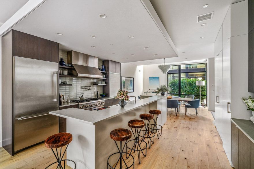 Set within a private, landscaped courtyard in the heart of Fitler Square, this architect-designed residence offers a rare combination of scale, privacy, and modern craftsmanship—moments from the neighborhood’s cafés, restaurants, parks, and river trails. One of a limited collection of custom townhomes, the home was thoughtfully conceived for elevated city living, where sophisticated design meets effortless functionality.
Spanning over 5,000 square feet across five levels, this 25-foot-wide residence features four bedrooms, four full baths, two powder rooms, a private elevator to every floor, and attached 2-car garage parking. Oversized windows and soaring ceilings flood the interiors with natural light, while curated architectural details—including solid wood doors, custom steelwork, and refined millwork—create a level of warmth and quality rarely found in contemporary construction.
The main level unfolds with expansive living and dining spaces anchored by a chef’s kitchen with quartz countertops, custom cabinetry, premium appliances, an oversized island, a walk-in pantry plus a built-in coffee bar. Walls of glass open seamlessly to a private terrace with a full outdoor kitchen, built-in grill, and wood-burning pizza oven—creating a true indoor-outdoor lifestyle rarely available in the city.
The second floor is soaked with natural light, offering a spacious family room with a gas fireplace and a private guest suite. Occupying its own dedicated level, the primary suite feels more akin to a luxury hotel retreat, complete with a custom dressing room and spa-caliber marble bath with soaking tub, oversized glass shower, double vanity, and heated floors.
The fourth level includes a dramatic double-height den, flanked by two bedroom suites and a full laundry room. The top level is designed for hosting, featuring a kitchen with refrigeration, a sink, and an ice maker that opens directly onto a skyline-view roof terrace with a fire pit and a powder room—an exceptional setting for evening gatherings above the city.
The lower level includes direct access to the garage, a mudroom with custom built-ins, extensive storage, and flexible space ideal for a gym, wine storage, or seasonal organization.
Residents enjoy the ease of a lock-and-leave lifestyle with HOA services that include professional landscaping, snow removal, twice-weekly private trash collection, and on-site property management. Additional highlights include 2 remaining years of tax abatement, multi-zone HVAC, and smart home features (Lutron programmable lighting, motorized shades, surround sound, and security cameras)
Positioned within walking distance of beloved neighborhood destinations including Ambrosia, Sally, Pine Street Grill, Trattoria Carina, Mr. Rabbit, and the green spaces of Fitler Square Park and the Schuylkill River Trail, the home also offers convenient access to Children's Hospital of Philadelphia, University of Pennsylvania, Drexel University, 30th Street Station, and Center City’s business and cultural districts.