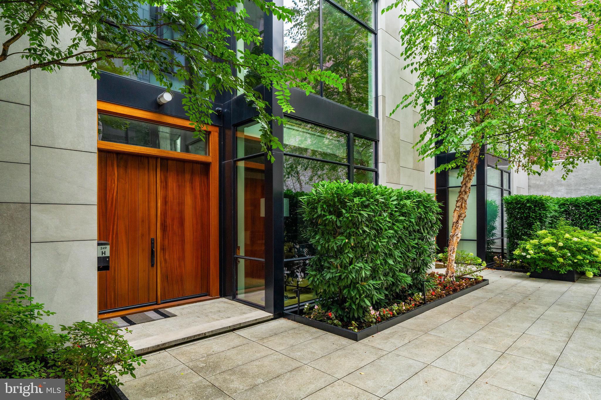 Sophisticated Fitler Square Townhouse with Elevator, Garage & Roof Terrace
Tucked within a private, landscaped courtyard, this custom-designed, 25-foot-wide townhouse spans more than 5,000 square feet across five levels of refined living. With four bedrooms, four full baths, two half baths, an elevator serving all floors, and 2-car garage parking, the home combines scale, elegance, and ease in one of Philadelphia’s most desirable neighborhoods.
The entry level opens to a welcoming foyer that leads into a light-filled living, dining, and kitchen space, designed for both daily comfort and entertaining. Anchored by an oversized island, the kitchen showcases quartz counters, custom cabinetry, a walk-in pantry with coffee bar, and premium appliances. The dining area easily accommodates large gatherings, while the living room connects through glass sliders to a private patio with outdoor kitchen—complete with built-in grill and wood-burning pizza oven—for effortless indoor/outdoor living.
The second level offers an expansive family room with a sleek media wall and gas fireplace, along with a guest suite featuring an en-suite bath. The third level is dedicated to the primary suite, with a gracious bedroom, custom walk-in wardrobe, and a spa-inspired bath with soaking tub, double marble vanity, glass shower, and heated tile floors. The fourth floor is defined by a dramatic double-height lounge, flanked by two additional bedroom suites and a full laundry room.
The fifth level is designed for entertaining, featuring a kitchenette with refrigeration, ice maker, and sink, plus glass doors that open to a skyline-view roof terrace with fire pit and powder room. The lower level provides direct garage access, a mudroom with built-ins, a large storage/flex space, and abundant closet storage.
Additional highlights include two-zone HVAC, tax abatement, and HOA services that cover landscaping, snow removal, a heated driveway, private trash collection twice weekly, and on-site property management.
Ideally located in the heart of Fitler Square, the home is steps from beloved neighborhood dining (Ambrosia, Sally, Trattoria Carina), cafés (Rabbit, Good Karma, Bacchus), and the green spaces of Fitler Square Park and Schuylkill River Park with its trails, dog runs, and sport courts. It offers quick access to Penn, CHOP, Drexel, 30th Street Station, the airport, and is within the Greenfield School catchment.