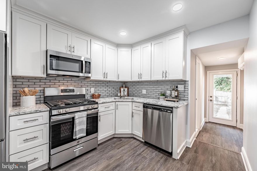 Discover this beautifully reimagined rowhome in the lively Hampden neighborhood, ideally located at 708 W 34th St—right along one of Baltimore’s most treasured residential streets. Known around the world for the annual Miracle on 34th Street celebration, this iconic block comes alive each year with dazzling lights, tradition, and an incredible sense of community. Homes here rarely become available, and it’s even more special to find one on the desirable even side of the street, where the handsome three-story residences sit gracefully elevated above the avenue.  This home seamlessly blends timeless character with refined modern updates. Step inside to an inviting open-concept main level featuring durable wide-plank flooring, recessed lighting, and an effortless flow designed for comfortable everyday living and easy entertaining. The living room centers around a sleek electric fireplace, creating a warm and contemporary focal point. In the dining area, a dramatic floor-to-ceiling natural stone accent wall adds texture and visual impact.  The kitchen is thoughtfully designed for both style and function, offering crisp white shaker cabinetry accented by brushed nickel hardware, granite countertops, a gray subway tile backsplash, and a full suite of stainless-steel GE appliances.  Upstairs, generous bedrooms provide peaceful retreats, complete with plush neutral carpeting and oversized windows that fill the home with natural light. High-efficiency ductless mini-split systems in the primary suite and additional living spaces allow for customizable, year-round comfort. The updated full bath features a modern stone-topped vanity, designer lighting, and a beautifully tiled tub surround.  Additional features include a clean, dry basement with original stone foundation walls—perfect for storage, a workshop, or potential future finishing—as well as a new high-efficiency water heater. Just moments from the acclaimed restaurants, boutiques, and nightlife along Hampden’s “The Avenue,” this move-in-ready residence presents a rare opportunity to own a fully renovated home on one of Baltimore’s most celebrated streets. For added peace of mind, the sale includes a home warranty, offering confidence and protection for the next owner.