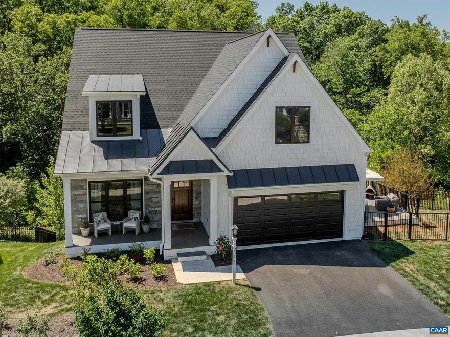 Like-new, stunning 3,700 sq ft modern farmhouse in Old Trail delivers 4 beds, 4.5 baths across three finished levels with designer finishes throughout. The soaring shiplap cathedral ceiling great room flows seamlessly into a chef's kitchen anchored by a La Cornue range, custom brass hood, Sub Zero refrigerator, quartz countertops, white oak island with farmhouse sink, walk-in pantry, and dedicated coffee station. The first-floor primary suite features a freestanding soaking tub, double vanity, and frameless glass shower. A dramatic home office with floor-to-ceiling built-ins, dining area, screened porch, and rear deck complete the main level. Upstairs, three well-appointed bedrooms share two designer baths. The finished basement is a true entertainment destination: a professional HD Golf simulator with movie theater and multi-sport packages - the same system installed in the private residences of top professional golfers worldwide - plus a full wet bar, recreation lounge, private bath, balcony, and unfinished storage space. Lennox HVAC, stacked LG laundry, oversized 2-car garage. Wooded walking trails behind the home offer privacy, Minutes to Downtown Crozet; 20 min to UVA and Charlottesville's Downtown Mall via I-64.