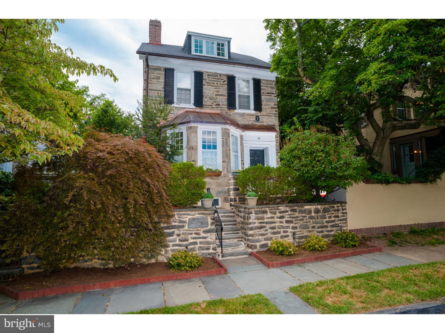 Built in 1872, this stone Colonial single home has been extensively updated, boasting modern conveniences with classic architecture and period charm.  The living room greets with a wood fireplace, bay window, and coat closet.  Living and dining rooms feature rosewood flooring and custom shutters.  A true entertaining kitchen awaits with custom wood cabinets, quartz countertops and built-in butcher block.  It has a Subzero refrigerator and double chiller, Thermador commercial 4 burner with griddle stove, second oven, Kitchenaid separate ice maker, Bosch dishwasher, island prep sink and slate flooring.  The kitchen connects with a conservatory dining area with a powder room with copper sink and soapstone vanity and a lovely side garden entrance.  French doors lead to a rear shady terrace with manicured gardens.  Upstairs, a master suite is appointed with double closets and a spacious master bathroom with hand-glazed tile, a jetted tub, separate shower, double sink and water closet with pocketed door.  In the rear, there is a second bedroom with closet. On the third floor, there is a patio door that leads to the large roof deck, a third bedroom with closet and a second full bath with large clawfoot soaking tub, shutters and white tile and a large hall closet.  A newer roof, newer heating system with central air with electronic air cleaner and humidifier, water softener, newer wiring with 200 amp service.  Original windows were rebuilt with modern glass for efficiency.  This home is easily walkable to shops, the train and Pastorius Park. Left rear 3 panels of fence (missing one and two current ones) to be replaced in 6 weeks by Everlasting Fence.