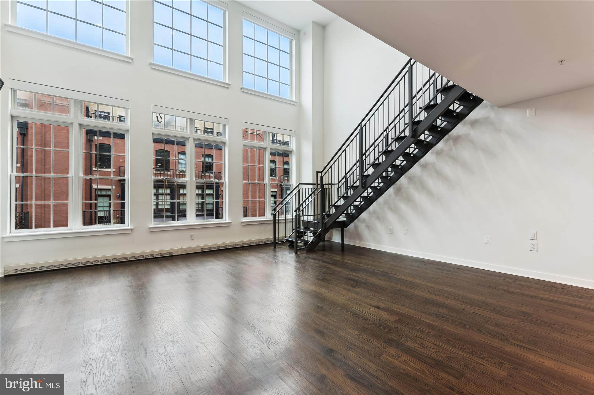 This fabulous two-story penthouse condominium at Gaslight Square exudes cool and sophistication as its architecture and features evoke the hipness of a warehouse loft, and luxurious appointments soften and refine. This grand luxury apartment unfolds across nearly 2,000 square feet on two floors, and features two bedrooms, two-and-a-half baths, a great room with 19-foot ceiling, gas fireplace, wall of windows and a loft, hardwood floors throughout, and a private outdoor terrace with skyline views. You'll love the open, gourmet kitchen with its oversized island, gas-cooking on a six-burner Wolf stove, a Subzero refrigerator/freezer, and ample cabinet and counter space. Both bedrooms offer updated ensuite baths, and professionally designed and installed closet systems in both walk-ins. The loft and main living room also offer smart storage solutions, while motorized blinds are to be found throughout the home. This condo conveys with two assigned garage parking spaces, and a private storage room. Finally, coming home with luggage and groceries is a breeze as direct elevator access delivers you from the parking garage right inside your home. Gaslight Square is a boutique condominium development offering both privacy and exclusivity, yet nestled among the businesses, restaurants, grocery stores, gyms and other amenities of two of Arlington's thriving neighborhoods: Courthouse and Rosslyn. While residing at Gaslight Square you'll be walking distance to two metro stations and Georgetown, and a short commute to other points in the District, Tysons Corner, Alexandria, and the area's two major airports. Originally built in 2013, Gaslight Square was intended as an ultra luxe, yet minimalist condo community for the most discerning of buyers. It consists of steel and concrete construction to ensure quiet and privacy from above and below. This pet friendly condo community is professionally managed, and you'll find its grounds impeccably maintained and landscaped.
