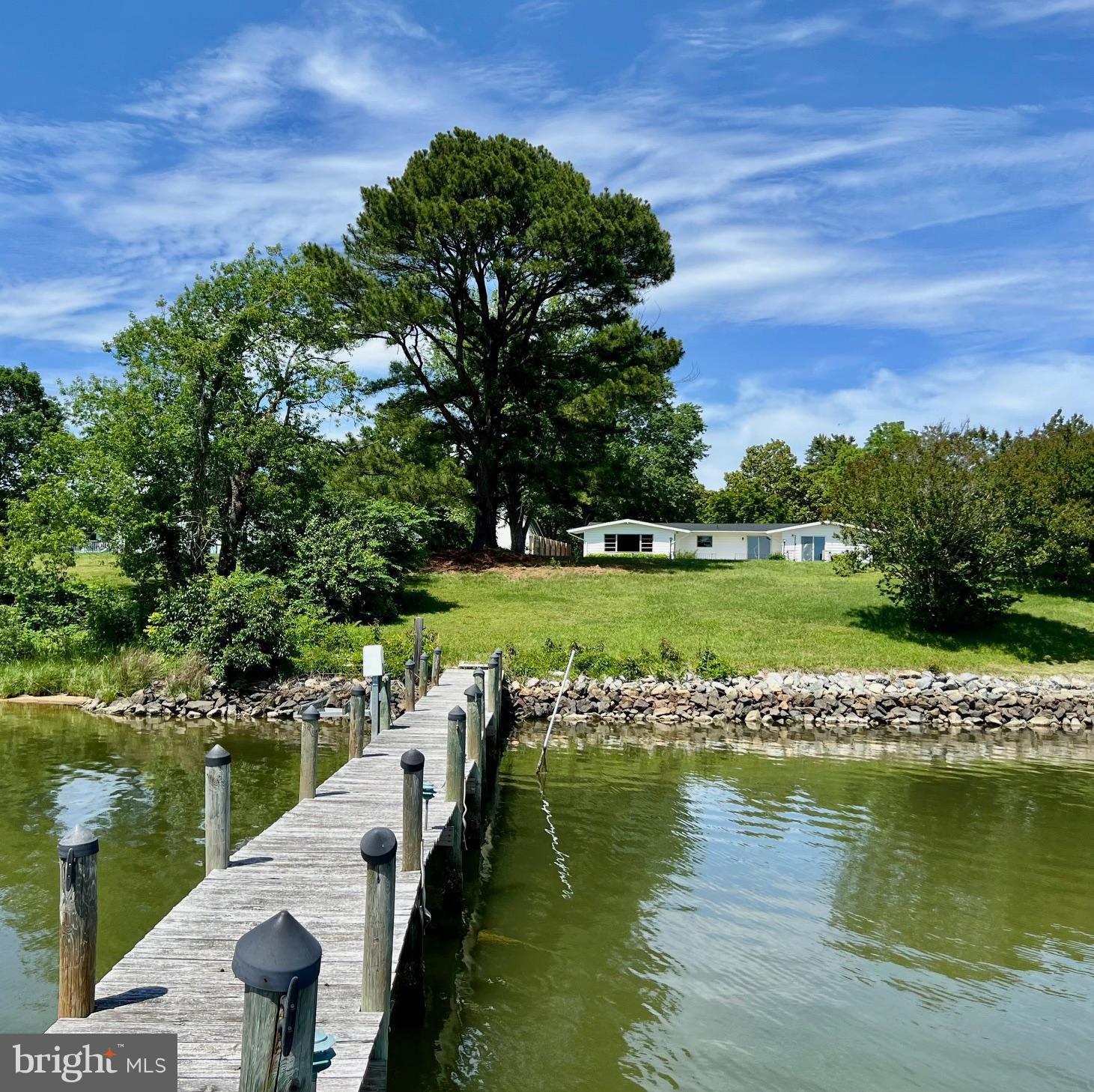 One level Waterfront Home on Lower Machodoc Creek, one of the best creeks in the Northern Neck! Enjoy beautiful Sunrises/sunsets and wide water views from this excellent location. Perfectly positioned on the .87 acre parcel with a Beautiful Shade Trees! Enjoy Breezes from the large waterside patio! The interior highlights include: Large Living Room with lots of glass, Large Formal sitting room, wood parquet floors, Oversized kitchen with lots of Cabinetry, waterside Primary Suite with dual closets along with access to the waterside deck, Tiled Primary Bath, 2 Guest Bedrooms, tiled Guest Bath, Half Bath, plus a 800 sq ft unfinished basement. Other great features: New Roof, New artesian well and fresh paint. Bring your vision to make this your own. With a little TLC and a few more projects to be completed this Gem will shine. Nice storage including an attached 22 x 24 garage, storage building and a covered boat storage location. This is a Prime water Location and elevation with rip-rap shore, a pier, boat lift, jet ski lift and rare deep water of 7-9 feet which will accommodate any boat.