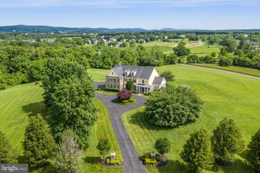 Photographs could never portray the beauty of this home, its views or the community.  Big Spring Farm, sought-after for its privacy and location near the Potomac River, enjoys a rare community trout stream that meanders and runs on “this particular lot” in a park-like setting. A true custom home and private estate, it sits proudly on 11+ dreamy acres. Marvel at the 360-degree views which are a must-see inside and out. This home completes the "wish list" of today’s Buyer who will fall in love with its natural, serene setting as the original owner has. They say in real estate that a home’s location is key – this is so true, and the architect of this home designed it with its rare topography in mind to accent so many breathtaking views. You will pause as you take in the mountainous landscapes and the natural beauty surrounding the home and numerous scenic vistas. If this were not enough, the rare spring-fed Trout Stream and infamous community Potomac "Riverwalk" with horse/jogging trails are also exclusive to the community and why Big Spring is so sought-after.  Breeze through (but not too quickly) the captivating foyer and grand staircase while becoming infatuated with the rolling acreage from the great room and its wall of windows - a pattern in also the sunroom and every room. On this main living level, find a family room with a stone-faced fireplace off the beautiful Gourmet Chef's Kitchen. To paint the perfect picture of living on acreage, while saturating the indoors with the outdoors, one should take a minute to pause while peering out from the breakfast room and even the formal dining room - serenity at every turn. No detail was overlooked when adding 3 walkouts to maximize the appreciation and convenience of owning your own acreage/land. Two walkouts to the rear yard are on the main level in the family and great rooms which step out onto a beautiful flagstone patio. Venture to the upper living area to an expansive Primary Suite that is complimented by not only a 3-sided gas fireplace and wet bar but also a veranda to enjoy morning coffee or simply relax overlooking the property. The luxurious Suite's Bath has a custom-tiled designer shower, a large spa tub and two separate vanities. The pristine condition of this home is so apparent when you enter not only the guest bedroom with a bath en suite but also the two other very large bedrooms and a shared full bath. All rooms from this upper-level offer spectacular views of the property and beyond.  Enjoy the luxury of this custom build with a gym room, media and game area, a full bathroom and unfinished storage/workshop area.  The 3rd is walkout is here and accesses the side yard from the finished lower level with a gym, full bathroom and large entertainment rec/game room.  With only 55 homeowners in Big Spring, few get to enjoy a community such as this. From the gazebo/picnic area at the water to the the historic barn used for events and a 2-Mile River Walk along the Potomac River (for runners and equestrians alike), the 450 acres of open space is a breath of fresh air amidst more developed neighborhoods. This is apparent with some homeowners able to produce award-winning grapes (vines) for wineries while others have horses. SORRY, NO COMMERCIAL BUSINESSES ALLOWED. All of this is only minutes away from downtown Leesburg's restaurants, shops and schools. Big Spring is only 20 miles from Dulles Airport and across the street from a Gary Player-designed Golf Course with flexible memberships available.  (New:  Birch hardwoods, new 50-Year Architectural Shingle Roof, carpeting, custom paint, appliances, more.  NOTE: Tax record is wrong - 1729 approximately finished in basement)