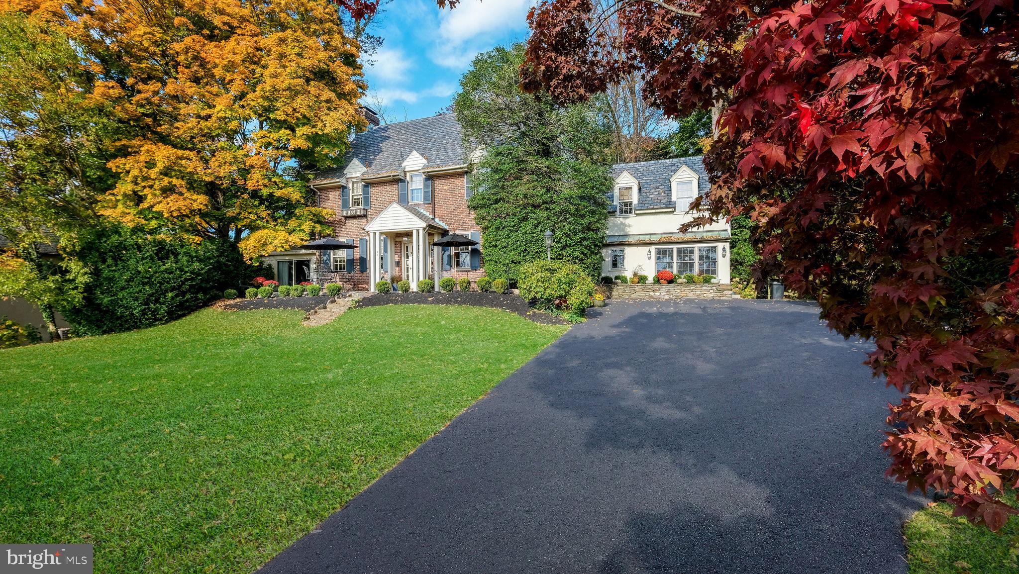 Welcome to 51 Golf View Road--a home set in the heart of Doylestown Borough that blends historic charm with premiere golf course views! This classic beauty rests on a gentle hill opening up to a vista of unobstructed views of the Doylestown Country Club Golf Course. From the vantage point of the gorgeous flagstone patio, enjoy sunrises and meteor showers over the rolling greens, to the vibrant seasonal display of summer fireworks, autumn's vivid colors, winter sledding and spring blooms! Step inside this classic 5+ bedroom, 4.5 bath Brick Home, thoughtfully designed in 1920 by renowned architect Luther Nash, and let the home's rich history unfold. The grand foyer, framed by 9-foot ceilings and a magnificent 3-story staircase, flows into the formal Dining Room with a custom, lighted corner cabinet and scenic views-an elegant stage for holiday gatherings. Just beyond, the step-down Living Room with a cozy fireplace, book-shelves and hand-crafted Mercer Tile accents creates a spot for quiet moments by the fire. The nearby Family Room, with a vaulted, wood-beamed ceiling, massive stone fireplace and wet bar, beckons to be used for family holidays, entertaining or casual relaxation. The gourmet Kitchen, outfitted with leathered black granite countertops, a double stainless sink, and premium appliances overlooks the lush backyard. The Kitchen combines classic elegance and functionality. Nearby, the home now includes a First Floor Bonus Suite with a private entrance and a VIEW! The Suite offers privacy and convenience, with a full handicap-accessible bath. A secret back stairway leads from the Bonus Suite to the upstairs. A charming powder room and laundry room complete the first floor. On the second floor, the light-filled Primary Suite provides an electric fireplace, a beautifully appointed separate dressing area with a marble sink, a walk-in closet, and a full bath with captivating golf course views. Three additional spacious bedrooms with dormer windows and custom built-ins complete this level, along with a cedar closet and hall bath. The third floor features a fifth bedroom, a full bath with a claw-foot tub, and extra storage. Set on one of the largest lots in the Borough, the property's mature trees, lush perennial gardens and stone walls offer privacy and beauty year-round. The fenced backyard, complete with a brick patio, is perfect for entertaining, while additional grounds behind the fence provide ample space for outdoor activities or even a pool! A Generac generator provides peace of mind. This extraordinary Doylestown Borough home presents a rare opportunity to own a residence in one of the Borough's most exclusive, tranquil settings. This premiere location invites you to walk to all that Doylestown Borough has to offer...the museums, the shops, the restaurants, the library, the train! This is THAT home on that street you have been waiting for.