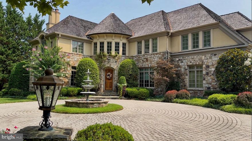 Idyllic European style residence immediately impresses you with its elegant front courtyard crafted from pavers, a stately fountain and extensive hardscaping.  Sitting on a little over 3/4 of an acre in Woodlea Mill, one of McLeans most impeccably landscaped neighborhoods, it features beautifully maintained, mature landscaping with a picturesque back yard complete with a flagstone patio, three tier rock pond and an ecurie. The exceptional light filled interior is as dramatically beautiful with its cathedral ceilings and custom architectural details.  A grand foyer with a curved staircase welcomes guests to the home and its formal living room with an antique French fireplace mantle, a bright and spacious formal dining room and a fully paneled library with built in shelving.  The gourmet, eat in kitchen sits adjacent to the two-story great room and both open up to the rear patio and provide scenic views of the grounds.  The great room features french doors, a wall of windows and a large stone fireplace with a staircase to the side leading to the top level.  A powder room, laundry and mudroom and entry to the 3 car garage completes this main level.  Two staircases provide access to the second floor where the amazing primary suite showcases a coffered ceiling, large master bath and a spacious walk in closet. The 3 additional bedrooms on this floor all have bathrooms en-suite as well.  The lower level of the home features an entertainment room with a fireplace, custom designed wine cellar, billiards area, fitness center, craft room and another large bedroom with en-suite bath.  The exterior is enhanced with a separately housed (Ecurie) potting shed and shed for motorcycle, bikes or kids mini vehicles. The yard features an in-ground irrigation system and a heavy iron gate.  A powerful whole house generator will also convey.  Finally, the Woodlea Mill neighborhood is highly sought after for its beauty, privacy and convenient location.  Just minutes from Tysons Corner and across from Spring Hill Recreation Center, the neighborhood is adjacent to the 267 toll road for easy access East to DC or West to Dulles Airport.