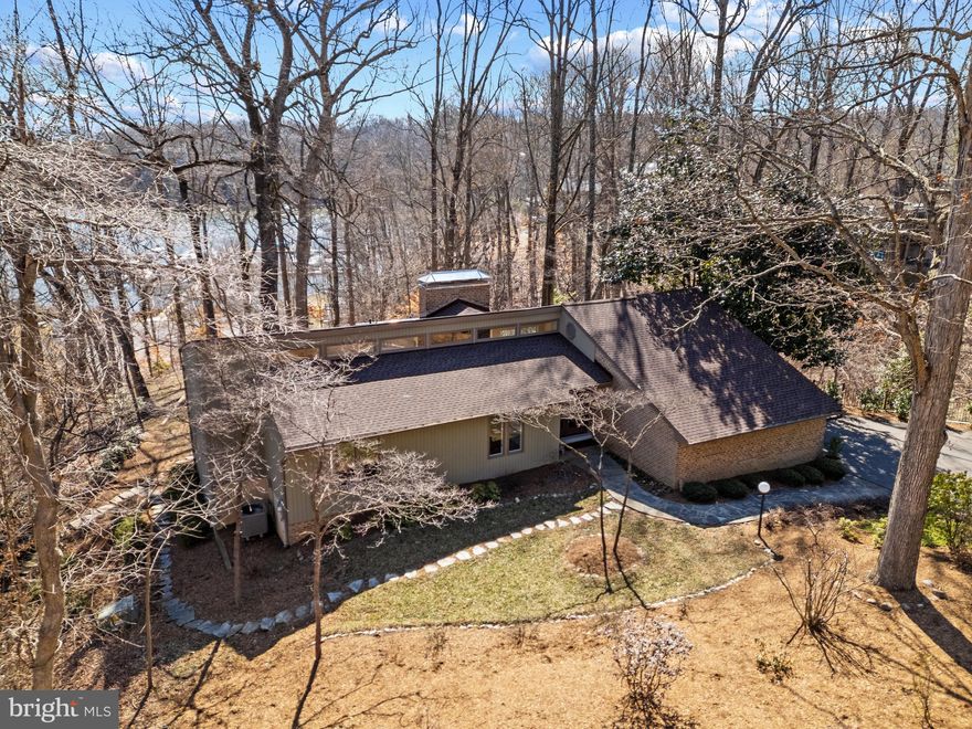 Stunning mid century modern home in the Downs on the Severn community of Annapolis.  This gem of a home is surrounded by beautiful landscaping and boasts gorgeous water views down the Severn River out to the RT 50 bridge. The expansive wrap around rear deck and patio below are perfect for entertaining or relaxing all year long. Enjoy the easy access from the backyard to the community marina below, featuring a brand new floating dock and relish in the perfect location with just a quick walk to the community pool, tennis courts and clubhouse.  Inside the home, the stunning interior boasts vaulted ceilings, walls of glass that frame the views and an open concept floor plan with gleaming hardwood floors. The sun-filled gourmet Kitchen with center island and a plethora of cabinets and counters flows into the spacious Living room and Dining area with the floor to ceiling brick fireplace as the focal point. A cozy place to gather on a cool winter night! It's the perfect layout for preparing a meal in the kitchen while still chatting with your guests gathered in the living room or dining area. The wall of sliding glass doors draws you out to the rear deck and the water views are captivating; creating indoor/outdoor living at its finest. Conveniently located on the main level are 3 bedrooms and 2 full baths, including the Primary bedroom suite with access to the rear deck and a luxurious spa like bath featuring a skylight for beautiful natural light, double sinks and huge walk-in shower. Head down the stairs to the lower level walkout with walls of glass to enjoy the Family room with additional fireplace, a spacious and light-filled bedroom with hall bath and an additional bedroom/bonus room that is perfect for a home office, gym or 5th bedroom. Numerous recent upgrades include refinished hardwood floors, new roof, new paint throughout, and much more. Located in Downs on the Severn, a sought-after waterfront and water privileged neighborhood, plentiful in amenities including 2 deep water marinas, clubhouse, tennis/pickleball courts and community pool. Welcome Home!