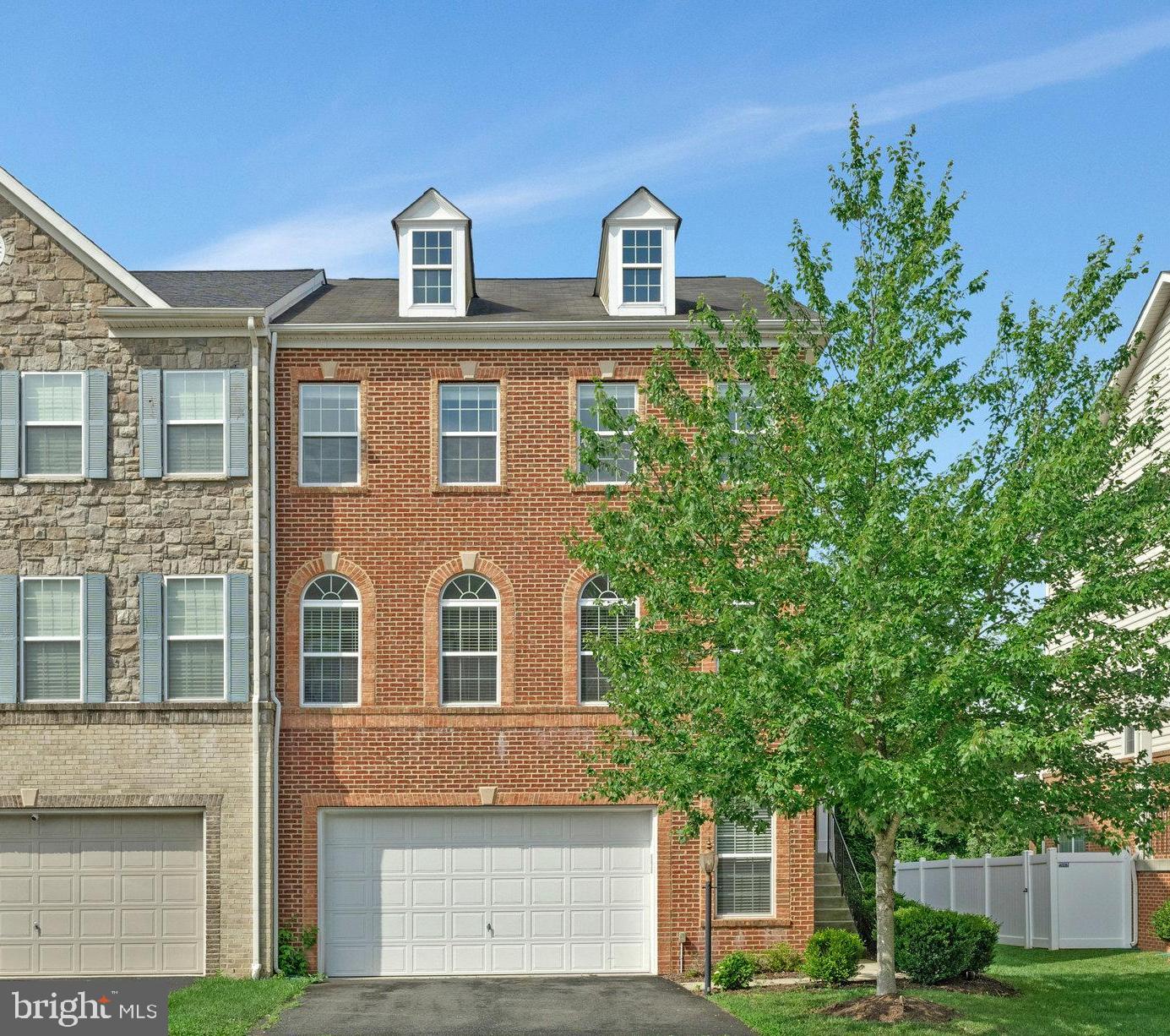 Stunning end-unit townhome backing to trees in sought-after River Pointe. This impeccably maintained 3 bedroom/3.5 bath home offers nearly 3,100 finished sq ft across three levels. Enjoy abundant natural light from extra side windows, hardwood floors, and an open-concept layout perfect for entertaining. The gourmet kitchen features white cabinetry, granite countertops, stainless steel appliances (2 years old), pendant and recessed lighting, and a breakfast bar that flows into a spacious family room with gas fireplace and stacked stone mantel. The upper level boasts a luxurious primary suite with tray ceiling, walk-in closet, and a spa-like bath with dual vanities and large walk-in shower. Two additional bedrooms, a hall bath with double sinks, and full-size laundry complete the upstairs. The fully finished lower level offers high ceilings, LVP flooring, recessed lighting, a full bath, and a huge recreation room. Step outside to a fenced backyard featuring a custom brick patio, under-deck roof, dual ceiling fans, and TV wiring ideal for year-round outdoor living. Residents of this community have access to various amenities, including a clubhouse, pool, trails, basketball courts, tennis courts and tot lots. This ensures there are plenty of opportunities for recreation and socializing. The townhome's convenient location is close to Wegmans, Trader Joe's and major commuter routes, shopping centers, and restaurants, making daily errands and outings effortless. Furthermore, the area is known for its wineries and breweries, offering additional leisure activities and options for exploration. Overall, this two-car garage townhome in River Pointe provides a comfortable and well-appointed living space, desirable amenities, and a convenient location that caters to various interests and needs.