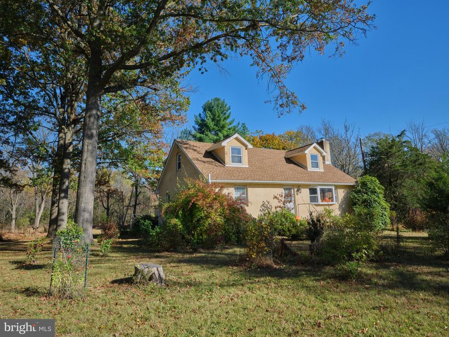 Set on 3.23 private acres, this four-bedroom Cape Cod stands in the peacefulness of Richland Township. Two first-floor bedrooms and full baths on both levels make the home easy and open. Refinished hardwood floors turn the morning light into a quiet, warm glow throughout the home. **  The open kitchen is designed to work and makes cooking and baking a delight, featuring a lots of counter space, a center island, a newer stove/oven and refrigerator… all with open views of the country setting. In the living room, the brick fireplace with its wood-stove insert turns cold nights warm and bright. **  The breezeway brings in the sun and makes a home for plants. The oversized two-car garage and large basement offer room for every tool and season. Newer roof… Newer septic… Newer radon system… and more! - Your new home offers comfort, security and reliability! **  Outside, the land opens wide, featuring colorful flowers and trees. The yard is perfect for gardens, and agri-pursuits, with space to wander and breathe. The driveway and garage offer plenty of room for parking. Discover country living that’s close to the roads that lead to and through Upper Bucks and the Lehigh Valley. Walk the property, experience the serenity—schedule your tour today.