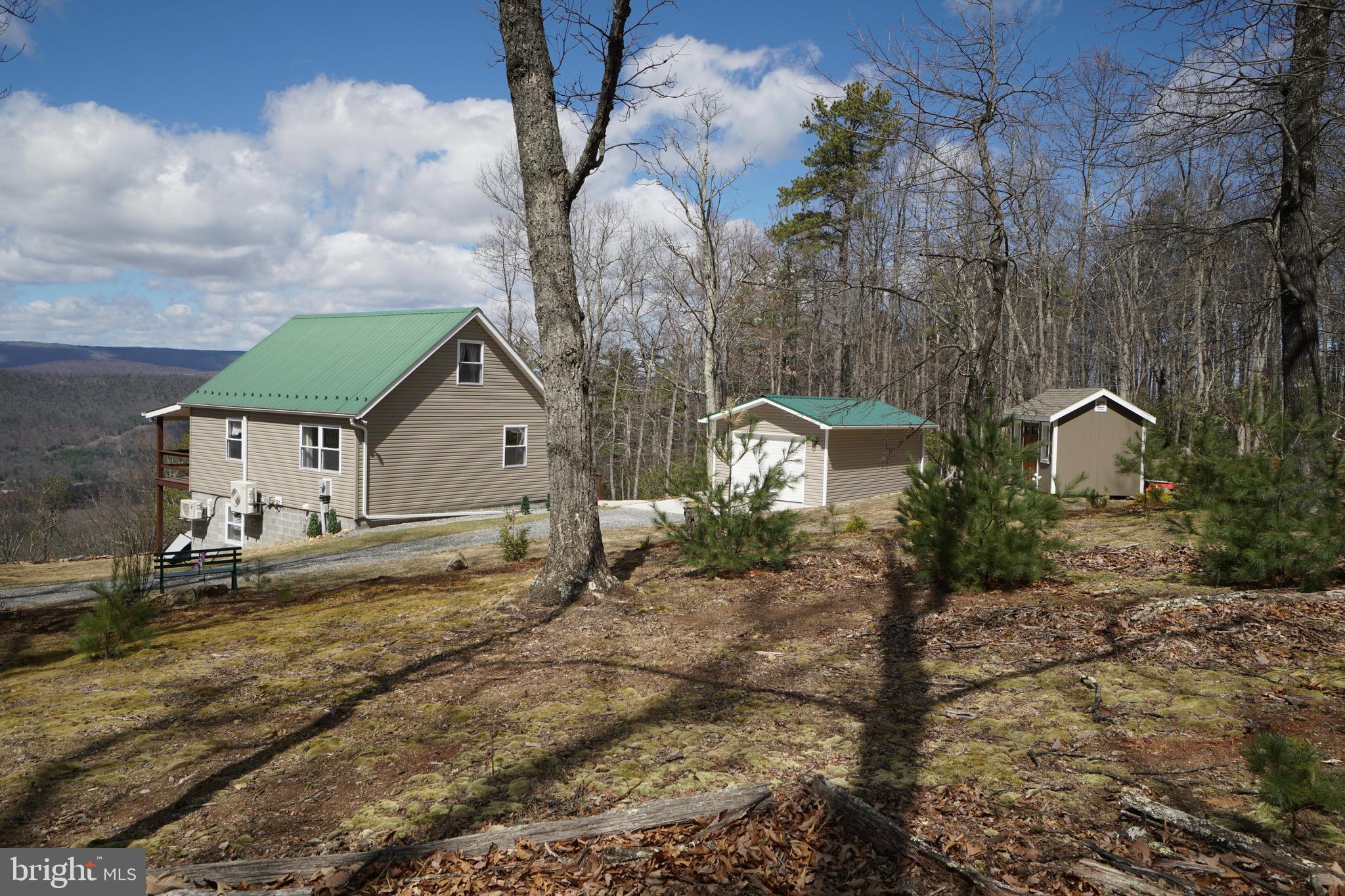 Panoramic Views from this lovely mountain cabin! Many Upgrades, including New Vinyl siding, New flooring throughout, Freshly painted walls, New Quartz countertops, New Gutters, New Doors, Brand New 14 x 24 Single Car Garage and a 8 x12 Storage Shed. This cabin is truly a gem. Mountain views on all levels. Open living area on main floor with 1st floor bedroom and bath. Upstairs you'll find a spacious loft, perfect for a private sitting area, office space or extra sleeping area for visiting guests. Downstairs you'll find a fully finished basement with 2nd living space, bedroom & bath. From the French Doors, walk out to the privacy of your hot tub and imagine sitting there in this beautiful mountain setting, favorite beverage in hand relaxing under the starry night sky. This home has been lovingly and very well maintained, so call for an appt. today. You won't want to miss out! Some covenants & restrictions apply. Water Source for Cabin is 1000 gallon Cistern. Yearly fee of $175 covers road maintenance and trash dumpster.