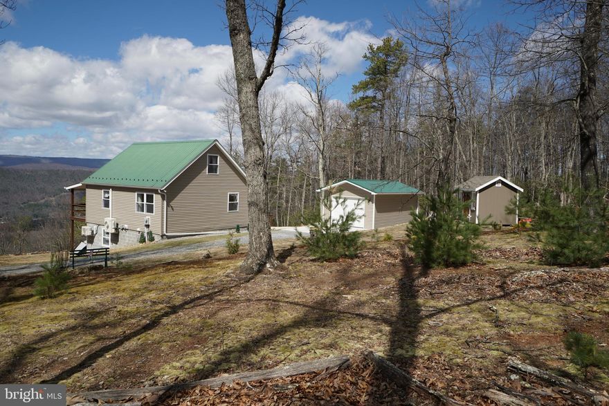 Panoramic Views from this lovely mountain cabin! Many Upgrades, including New Vinyl siding,   New flooring throughout, Freshly painted walls, New Quartz countertops, New Gutters, New Doors, Brand New 14 x 24 Single Car Garage and a 8 x12 Storage Shed. This cabin is truly a gem.  Mountain views on all levels. Open living area on main floor with 1st  floor bedroom and bath.  Upstairs you'll find a spacious loft, perfect for a private sitting area, office space or  extra sleeping area for visiting guests. Downstairs you'll find a fully finished basement with 2nd living space, bedroom & bath. From the French Doors,  walk out to the privacy of your hot tub and imagine sitting there in this beautiful mountain setting, favorite beverage in hand relaxing under the starry night sky. This home has been lovingly and very well maintained, so call for an appt. today. You won't want to miss out! Some covenants & restrictions apply.  Water Source for Cabin is 1000 gallon Cistern. Yearly fee of $175 covers road maintenance and trash dumpster.