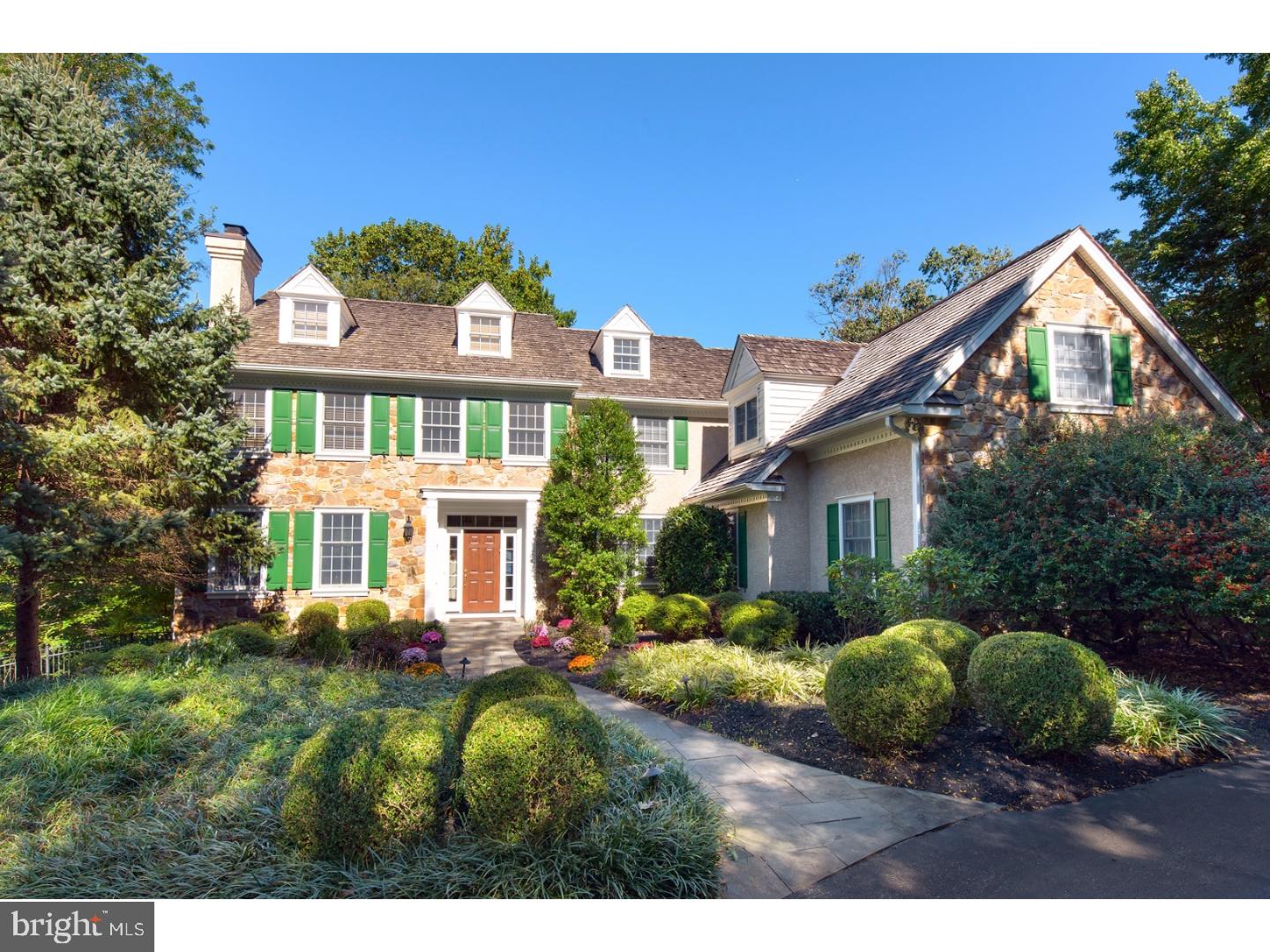Stately yet welcoming 4-5 bedroom, 5 1/2 bath stone colonial home set on an idyllic acre+ parcel in premier Penn Valley location with generous yard, beautiful plantings and magnificent pool.A flagstone path and circular drive lead to a sunlit two story Foyer with traditional turned stairs and balcony overlook,cleverly customized as a second level Library.The Den:Office with handsome hardwood floors sits to the right of foyer while the Living Room with painted wood mantle and marble surround fireplace is positioned on the left. Through a wide cased opening the formal Dining Room features deep wainscoting,two piece crown molding and swinging door to an exciting newly updated white gourmet Kitchen with honey-toned stone counters, high ceilings,large center island and chef's quality appliances. For ease of service, steps away is the Breakfast Room with sliding French door access to a recently replaced wide deck with ambiance and stair lighting leading to the pool and lower rear yard. With commanding ceilings, and two walls of exceptional, custom built-in shelving, the Family room is brightened by two exposures of light and warmed by a gas burning fireplace. The second level provides deluxe retreat space with an elegant sitting room off a beautifully detailed Master Bedroom. Beyond, a marble Bath with corner tub and standing shower create a spa-like experience, adjacent to large, separate outfitted walk-in closets. Two additional bedrooms and two baths as well as ample storage complete this level while a large suite with private bath are accessed by an architecturally pleasing open staircase on the third floor. The lower level is surrounded by windows and walks out to a flagstone terrace through full sized french doors to the rear and side yards, pool and spa. Large recreation room, tv area, gym and area once purposed as an additional bedroom offer unique relaxation or entertaining space with granite topped wet bar, shelved closets and full bath. A fresh, turn-key residence filled with natural light with easy access to center city.