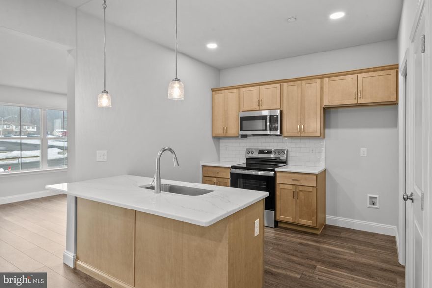 This gorgeous interior unit, modern craftsman-style home turns heads with its eye-catching stone facade, shake accents, and charming front door.  The heart of the home features a stunning, upgraded kitchen with sandalwood cabinets, quartz countertops, and a center island — perfectly connected to the dining and living spaces for easy entertaining or cozy nights in.  The open living spaces is a wide open, soaring great room with vaulted ceilings that instantly feels bright, airy, and welcoming.  Rear sliders lead to composite decks or concrete patios, depending on grade.  Upstairs, the spacious primary suite is your private retreat, complete with a primary bath with double bowl vanity and a walk-in closet big enough to impress. Two additional bedrooms, a full bath, and an oversized linen closet offer space for everyone.  These townhomes are designed with three professionally designed color palettes — so whether your style is bold, warm, or cool and modern, there’s an Addison that fits your vibe. Plus, this is truly low-maintenance living — the HOA takes care of lawn care and snow removal. Pair that with an oversized one-car garage and a location in charming Fleetwood, and you’ve got the ultimate in carefree, luxury townhome living.  One more thing...backed by the one-year Builder Warranty, we've got you covered!