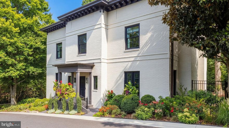Prominently positioned within a highly distinguished enclave of just 32 luxurious residences in the heart of Washington’s coveted Berkley neighborhood, 4802 Kemble Place is a stunning transitional Colonial, meticulously constructed, impeccably maintained, and thoughtfully enhanced to embody the very best of refined, quiet luxury. Notably, the property rests on one of the largest lots in the entire community — a rare and highly prized distinction that elevates both its presence and privacy.Striking curb appeal begins with the home’s classic symmetry, further accentuated by bold dark detailing set against the freshly painted light brick façade. A lacquered front door welcomes you into a grand foyer, where a sweeping staircase gracefully ascends within a dramatic three-story atrium. Embassy-sized formal living and dining rooms flank the foyer in a traditional center-hall configuration, each anchored by roaring fireplaces adorned with contrasting marble mantels. The living room offers a dignified yet inviting retreat, pairing light tones with rich millwork, while the dining room makes a designer statement with deep turquoise walls, heavily veined marble, and avant-garde fixtures. A true butler’s pantry seamlessly connects to the chef’s kitchen — a generously scaled space centered around a substantial island and framed by tranquil wooded views. The adjacent breakfast area opens to the expansive rear deck, effortlessly blending indoor and outdoor living. Nearby, the family room serves as the heart of the home, distinguished by a rustic walnut wood accent wall, walls of glass, and a welcoming fireplace. The second level is largely devoted to the lavish primary suite — a private sanctuary introduced by a 21-foot-long bedroom. Three separate dressing rooms with extensive custom built-ins provide exceptional storage, while the marble-clad bath exudes spa-like luxury with separate vanity and water closet rooms, a jetted soaking tub, and a walk-in shower. Two additional well-proportioned bedrooms share a Jack-and-Jill bath on this level. The top floor features two mirrored bedrooms, each with generous walk-in closets and access to an additional Jack-and-Jill bath, offering flexibility for family or guests.
The lower level continues the home’s elevated design with a sophisticated recreation room wrapped in rich, moody tones. A tiled walk-out fitness center with laundry facilities, a stylish powder room featuring a retro wall-mounted sink, a sixth bedroom suite, and direct access to the attached two-car garage complete this level. Outdoors, the property truly differentiates itself. Fully fenced, remarkably private, and shaded beneath a soaring wooded canopy, the expansive rear lawn is level, serene, and exceptionally rare for the neighborhood. As one of the largest lots among the enclave’s 32 homes, it offers space and tranquility seldom found in this premier setting. A generous brick paver patio enhances the landscaped grounds, creating the perfect backdrop for al fresco dining and entertaining. Exquisitely finished inside and out, and ideally located moments from Georgetown, Downtown Washington, and major commuter routes, 4802 Kemble Place represents a rare opportunity to own a distinguished residence in one of Washington’s most sought-after communities.