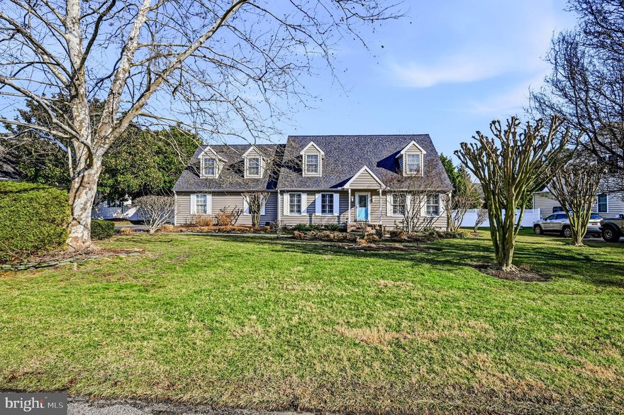 Ready for immediate occupancy in the prestigious Rehoboth Beach Yacht and Country Club, this beautifully updated 4-bedroom Cape Cod offers the perfect blend of coastal charm, modern comfort, and prime location. Just minutes from the vibrant downtown area, iconic boardwalk, outlet shopping, and the stunning beaches of Rehoboth Beach, you’ll enjoy the very best of beach living—tucked away in a private, sought-after community. Live poolside in style as you enter a spacious living room featuring hardwood floors, elegant board and batten trim work, and French doors leading to the updated kitchen. The kitchen is beautifully appointed with textured leathered granite countertops, classic subway tile backsplash, newer stainless-steel appliances, a wine fridge, and updated flooring—ideal for gathering and entertaining. Just off the kitchen on the main level, the sunroom provides an additional light-filled gathering space overlooking the pool deck and backyard, creating seamless indoor-outdoor flow. The main-level primary suite offers comfort and convenience with a spacious bath featuring a double vanity, standing shower, jetted tub, and walk-in closet. A main-floor laundry room and updated half bath complete the first level. Upstairs, a custom railing accents the staircase, paired with a hallway adorned with custom shiplap that evokes a relaxed coastal feel, leading to three generously sized bedrooms and a well-appointed full bath with tub shower. The second level, along with the living room and primary bath, has been freshly painted, offering a crisp, move-in-ready feel. Outdoor living is where this home truly shines. An expansive rear deck overlooks the beautiful custom designed in-ground pool, creating the perfect setting for summer fun and effortless entertaining. The fully fenced backyard offers privacy, lush landscaping, and space to relax after a busy day at the beach or boating. An outdoor shower adds convenience for rinsing off sandy toes before enjoying a poolside evening with family and friends. Additional highlights include an expanded side-entry two-car attached garage with ample room for beach gear, pool toys, and bikes. Recent improvements provide peace of mind, including a new roof and water heater (2026), both HVAC systems replaced in 2020 and 2021, new retractable awning, plantation shutters, encapsulated crawl space with sump pump, and impressive outdoor lighting. Conveniently close to town yet privately situated, this home in Rehoboth Beach Yacht & Country Club perfectly blends elegance, comfort, and the ultimate coastal lifestyle.