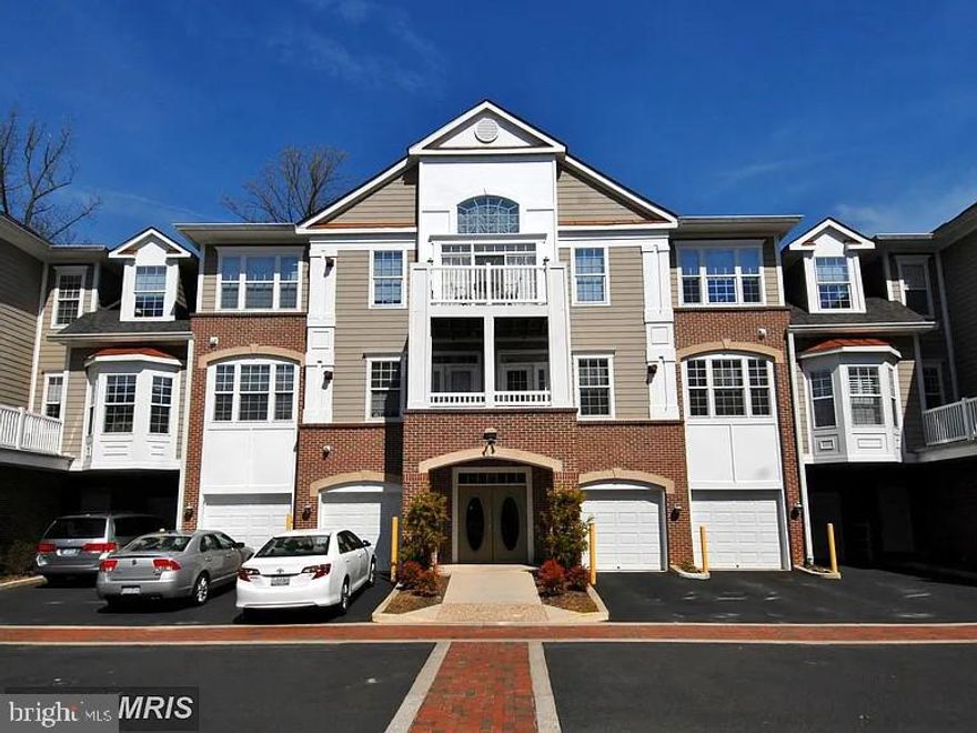 Traditional elegance enhanced with meticulous craftsmanship and thoughtful design elements throughout. Step inside to discover an open floor plan that seamlessly connects the living areas, adorned with crown moldings and chair railings. Rich hardwood floors flow throughout, while large windows in this corner unit invite lots of natural light, framing picturesque views of the surrounding trees and woods. The cozy fireplace, complete with glass doors and a charming mantel, serves as a focal point for gatherings. The kitchen is a culinary delight, featuring upgraded countertops and a suite of modern appliances, including a built-in microwave, range, and dishwasher. The convenience of in-unit laundry room with washer and dryer adds to the ease of living. The garage space for this unit is just across the hallway from the unit's door making access extremely easy.  Outside, the property boasts extensive hardscaping and well-maintained sidewalks. Enjoy the fresh air from your private balcony, ideal for morning coffee or evening relaxation. The community amenities include a library, party room, and picnic area, fostering a vibrant social atmosphere. Located in a suburban setting, this residence is conveniently close to transportation options, ensuring easy access to the wider area. With an attached garage and security features, this home offers both comfort and peace of mind. Experience the perfect blend of luxury and community in this exceptional property.