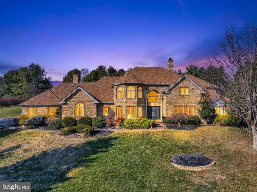 Prepare to be impressed from the moment you arrive at this exceptional estate, tucked at the end of a quiet cul-de-sac on nearly an acre of beautifully landscaped grounds. A brick paver walkway leads to a striking double-door entry framed by stately columns, setting the tone for the craftsmanship and attention to detail found throughout the home. Step inside to a dramatic foyer with soaring ceilings and stunning wide-plank rustic white oak hardwood floors finished in a soft, water-based matte that preserves their natural brightness. The sun-filled living room showcases a grand architectural window that perfectly frames peaceful backyard views. The entire main level has been thoughtfully redesigned with high-end finishes, including custom trim work, upgraded hardware, designer lighting, elegant chandeliers, and arched built-ins that add both beauty and function. Entertaining is effortless in the formal dining room, highlighted by a tray ceiling and generous space for gatherings. The showstopping kitchen is a true centerpiece—completely reimagined with premium Monogram appliances, gas cooking with a built-in griddle, honed marble counters and backsplash, and an oversized island featuring seating, a drawer microwave, warming drawer, farmhouse sink, panel-front appliances, and a nugget ice maker. Multiple pantry cabinets with pull-out shelving keep everything perfectly organized. Open to the kitchen and breakfast area, the inviting family room features exposed beams, tongue-and-groove cathedral ceilings, and a wood-burning fireplace flanked by custom built-ins. The adjoining breakfast nook includes a handcrafted bench with hidden storage. A standout laundry room offers abundant counter space, cabinetry, a sink, and even a built-in ironing station, while the custom mudroom provides cubbies for every member of the household. The main level also includes a private guest bedroom with a full bath nearby, while the primary suite is thoughtfully positioned on the opposite side of the home for maximum privacy. This luxurious retreat offers dual walk-in closets, a sitting area with a glass fireplace, a distinctive tray ceiling, and an adjoining flex room ideal for an office, nursery, or dressing room. The spa-inspired primary bath is nothing short of spectacular with heated floors, double vanities, a large soaking tub, and a multi-jet shower with rainfall head. Upstairs, you’ll find three spacious bedrooms, each with walk-in closets and full baths. One bathroom features a jetted tub, while another offers double sinks—perfect for guests or extended family. The lower level expands the living space even further, offering multiple rooms suited for a gym, office, hobby space, or studio, along with a dedicated craft room complete with ventilation fan. A second kitchen, expansive recreation room, and a media room for creating an entertainer’s dream.  Outdoor living is just as impressive. Relax in the screened-in porch while enjoying the soothing sounds of the waterfall, or host gatherings on the paver patio overlooking the pond, manicured gardens, and lush landscaping. The whole-house sound system extends outdoors, making this space ideal for warm-weather entertaining. With its unmatched design, versatile layout, and serene setting, this remarkable home offers luxury living at its finest. Opportunities like this are rare—schedule your private tour and experience it for yourself.
