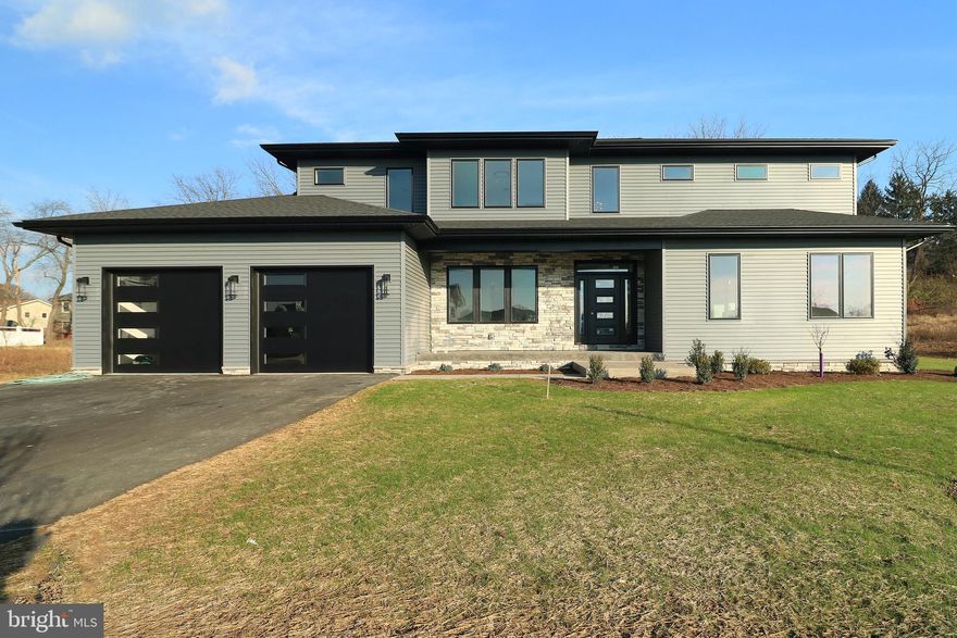 Welcome to 253 Farmhill Drive in premier Winfield Heights! Currently under construction with late November 2024 completion date.  The photos in this listing are from a similar home built by GEM in 2023 and are not of 253 Farmhill Drive. This GEM Homes modern prairie home boasts high end finishes, nine foot first floor ceiling height, 5 bedrooms, and 4.5 baths including a first floor bedroom/office and full bath with a tiled shower and frameless glass door. Plentiful light hickory hardwood flooring shines throughout the main floor, stair treads, upstairs hallway and master bedroom. Lots of large windows provide for plentiful natural light throughout. The impressive chef's kitchen features plentiful custom, Amish handmade solid-wood white Mission style cabinetry with upper glass cabinets going to the ceiling, a large island with a breakfast bar, a walk-in pantry, quartz countertops, Bosch and GE Profile stainless steel appliances including a 36" 5 burner gas cooktop and a double oven, a tiled backsplash, and undercabinet, pendant and recessed lighting. The sizable dining room is perfect for entertaining, while the expansive family room with abundant windows, recessed lights, ceiling fan, gas fireplace with stone hearth, and built-in window seats is great for relaxing. Your generous owner's retreat boasts hickory flooring, recessed lights and a ceiling fan, a walk-in closet, and a beautiful luxury bath with a furniture grade vanity, quartz countertop, a large tiled shower with a frameless glass door, and a free-standing soaking tub. The ample-sized 2nd floor laundry room has more custom cabinetry and a utility sink. Relax in the cheerful sunroom, chill on the shaded stamped concrete front porch, or gather on the rear stamped concrete patio. The tiled mudroom is the perfect out-of-sight drop zone, while the oversized two car garage provides hobby space, a utility sink, and has stairs to the unfinished basement. 2 separate gas HVAC systems provide total control and comfort throughout the house. The lower level, which features a finished staircase, nine foot ceiling, pre-plumbing for a future full bath, an egress window, and stairs to the garage provides for plentiful opportunities for a future fit-out . Additional features are a mix of chrome and black bath, door and light fixtures, black metal railing balusters, solid core doors, solid wood trim and solid closet shelving throughout, framed bath mirrors, and custom tiled showers and tub surrounds throughout.  Close to Penn State's Campus, Mt. Nittany Medical Center, and downtown State College, yet tucked away in a quiet spot with peaceful views of farmland and mountains, you'll appreciate this location!