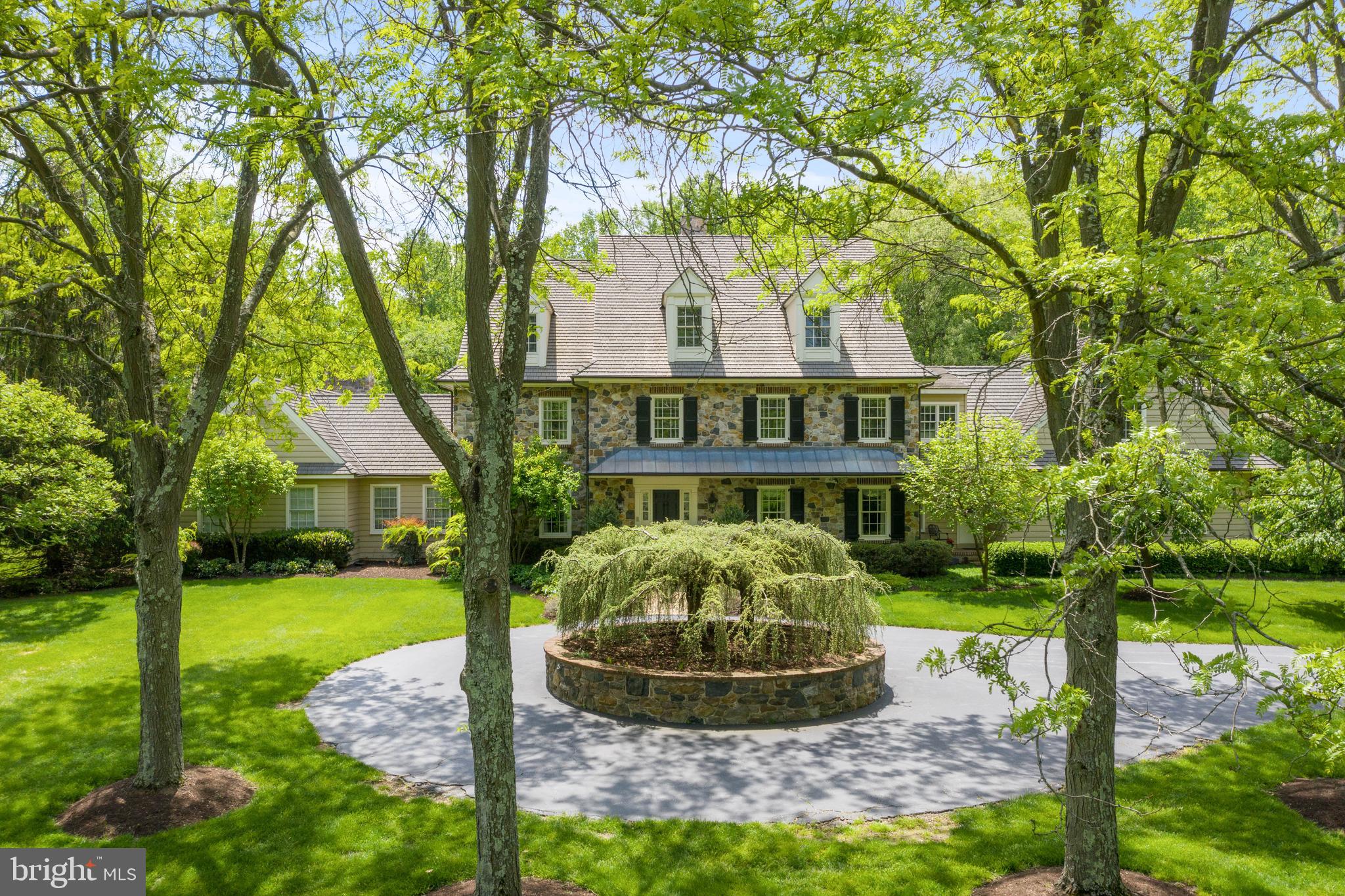 Formality meets casual luxury in this classic estate on 6.8 idyllic open and wooded acres in the private community of Bittersweet. A perfectly suited family home built by Dewson Construction, the area's premier custom home builder, with superior craftsmanship and exceptional attention to detail. Traditional architecture and quality materials make this updated, meticulously maintained property a standout. Natural stone walls flank the driveway entrance and are carried through the exterior of the home and repeated as interior accents. The cedar roof is enhanced with copper gutters, downspouts, accent roof and lighting. Reclaimed wide plank floors with brick accents anchor the main level. Crown molding and custom millwork detail the formal living room, gracious dining room, second office and luxurious main floor master suite, while hand hewn beams accent the informal spaces. Brand new Wolf stainless appliances complement the Sub-Zero refrigerator and Gaggenau steamer in the custom kitchen and wet bar, topped with granite and limestone counters. A sunny breakfast room and sunroom access the blue stone back patio and brick paths around the perimeter. Formal and informal powder rooms, generous pantry, three fireplaces, second staircase and a mudroom with cubbies add to the main floor amenities. Natural light fills the spacious upper level with 4 bedrooms, 2 jack-and-jill baths one au pair/in-law suite, and laundry with room for appliances. Use your imagination to complete the walk-up bonus space on third level. The lower level is well appointed for billiards, fitness, or media, served by wet bar and powder room. An additional finished room has wine cellar potential, and a cedar closet, ample storage and stair access to the 3-bay garage add to the utility. An inviting Lagoon pool is in harmony with the architecture featuring brick coping and a natural stone spa with waterfall, surrounded by lush garden and landscape. Horses are permitted. 3 Bittersweet is a rare find, offering the discerning buyer total privacy in an exclusive location, located in top ranked Unionville Chadds Ford school district, convenient to Wilmington, Philadelphia and beyond.