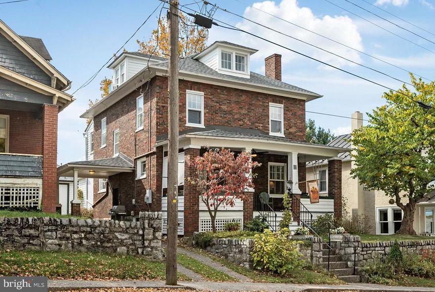 LOWER INTEREST RATE FOR YOU…..Sellers are offering  you 2 percent of sales price so you can buy down your interest rate with an initial 2/1 interest rate buydown OR use the 2% seller concession for your closing costs on this classic brick “American Foursquare” house in Winchester’s historic district.  This very well maintained 1928 home was designed and built by “ole time” craftsmen who had an appreciation for solid, quality construction. What better way to spend wonderful lazy evenings or morning coffee than on the expansive 23-foot long front porch with a ceiling fan. This 4 bedroom, 2 bath home is located in the historic Winchester “Potato Hill” neighborhood and just a few blocks from old town’s vibrant Loudoun Street mall. Enjoy numerous locally owned shops, historic attractions, street festivals, city sponsored activities, museums and restaurants. Among the many features are landscaping that emphasizes native trees, shrubs, wildflowers and ferns. The 16x18 wooden rear garage  has electrical service and is on the footprint of the original 1928  garage with a new concrete pad, 2 doors, copper roof, gutters and downspouts. In additon, there is an attached carport over the driveway. Hardwood floors in the living room and dining room, laminate in the remainder of the main level with pine flooring on the 2nd and 3rd floors with some carpeting. There are wooden blinds on most of the 1st and 2nd floor windows along with 7 ceiling fans. The unfinished basement has a concrete block foundation and a concrete floor. An extra commode and utility sink are located in the basement. The interior walls are mostly plaster but also include some drywall, brick and pine paneling. This all-electric home features heating and air conditioning supplied by two high-efficiency inverter heat pumps installed in 2023 and seven mini-split air handlers on the first and second floors. High-efficiency 50-gallon hybrid heat pump water heater was installed in 2023. Stacked washer/dryer (new in 2025) conveys. Internet and TV by GloFiber high speed glass fiber cable. The owners have never used the fireplace. Note that the square footage in the city tax records is less than the actual size according to the seller's records. Buyers should  confirm the square footage.
THE AMERICAN FOURSQUARE HOME…….From Mail-Order Home to Iconic Architecture Imagine the United States in the late 19th century in the midst of a growing economy and modernization. Urban communities were developing fast with more Americans leaving rural areas to pursue employment opportunities in the cities. It was a time when families moved away from their multi-generational residences and aspired to live in their separate homes.Enter the Foursquare, one of the most popular styles in the U.S. from the mid-1890s through the late 1930s during the economic boom that resulted in a greater demand for housing. Often mistaken for a Colonial home, the Foursquare is considered a variant of the Prairie Style and is sometimes called “Prairie Box.” With its boxy shape and simple design, the Foursquare – so-called because of its typically square footprint – was a reaction against the ornate and dramatic embellishments of other Victorian-era styles of the period.
