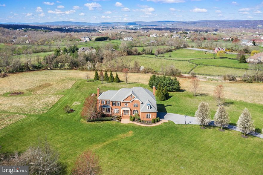 A gorgeous view from every window (even the laundry room:)! Immaculate and resplendent all-brick custom home on 11.7 acres with pool, located in a horse- and farm-friendly enclave neighborhood, stunning sunrise and sunset views, only 8 miles to downtown Leesburg and 10 miles to the toll road, on a cul-de-sac of $1million+ custom homes, this spectacular, truly rare property is offered for resale for the first time.  Sip your morning coffee on the front porch and watch the stunning sunrises. Then in the evening, enjoy the show-stopping sunsets while relaxing on the back deck or around the beautiful pool. This meticulously maintained property offers an extremely rare combination of close proximity to commuter routes, paved roads (except for a 400 yard stretch of Hampton Rd), privacy, views, and high speed internet availability. Totally refreshed and move-in ready, this house is an entertainer’s dream, with a spacious, open floor plan and superb flow. It’s also a house that's plenty big for at-home school and working from home concurrently. Almost 12 acres to use for horses, chickens, gardening, or just to have and enjoy the serenity.  Flooded with natural light, this 4+ bedroom, 5.5 bathroom home boasts an en-suite bath in every bedroom, gourmet kitchen open to family room with coffered ceiling, 4" oak flooring throughout the entire main and upper levels, office on main level, 4 fireplaces (2 gas and 2 wood-burning), huge walk-in pantry, custom trim work throughout --too many special features to list. The primary bedroom is to-die-for with a full wall of windows; tray ceiling; separate room that could be used as a 2nd office, a nursery, a yoga room, etc; two walk-in closets; and spa-like primary bathroom with heated floors. The walk-up basement is fully-finished with a 2nd kitchen, full bath, rec room, exercise room and doorway that leads to the pool.   Don't miss out on this unbelievable, one-of-a-kind property! Showings begin Thursday 4/8. Property is in land use. Seller not responsible for rollback taxes. Comcast internet being  installed in neighborhood as I write.