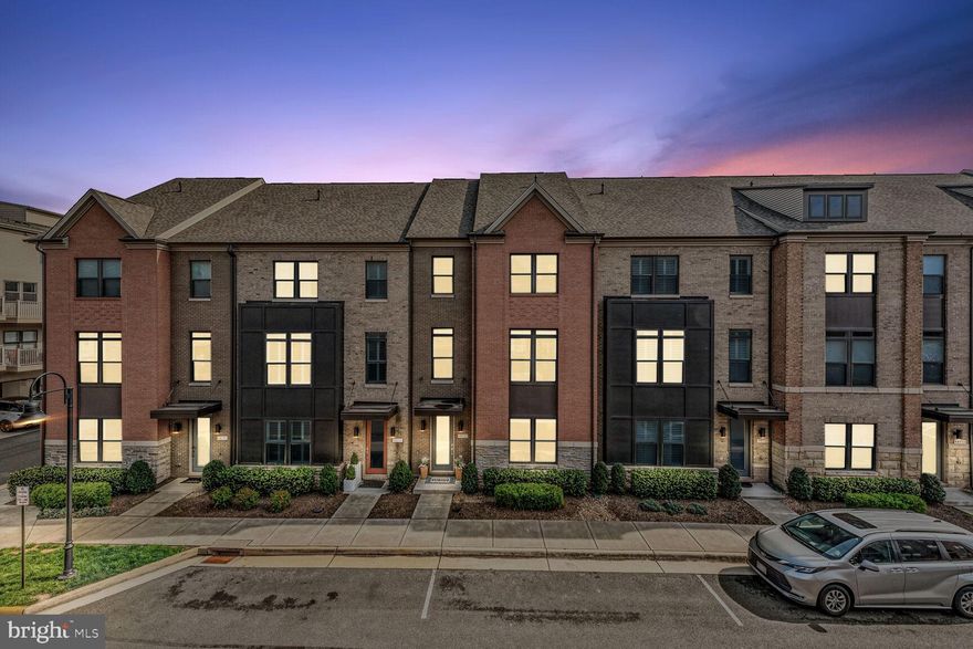 This rare North-facing 4-level townhome in the highly sought-after One Loudoun offers an exceptional living experience that combines modern design, sophistication, and convenience. This home is perfect for those who value both elegance and functionality. As you step inside, you’re greeted by a spacious recreation room on the first level, complete with wide-plank engineered hardwood floors and an abundance of natural light. This level also offers access to an oversized two-car garage with epoxy-coated floors and additional under-stairs storage. Ascend the upgraded oak hardwood steps to the second level, where you’ll find 10-foot ceilings and a stunning open-concept layout. The gourmet kitchen features premium stainless steel appliances, including a gas cooktop and double wall oven, soft-close cabinetry, and a 12' quartz island with space for six barstools—ideal for hosting. The large dining area flows seamlessly into the great room, highlighted by a beautiful wood plank accent wall. A spacious balcony off the kitchen is perfect for al fresco outdoor dining and entertaining. The third level is dedicated to comfort, with plush carpeting and premium 8lb padding throughout. The spacious primary suite offers a tray ceiling, dual closets, and a luxurious en-suite bathroom with dual vanities, a walk-in tiled shower with a built-in bench, and a private water closet. Two additional generously sized bedrooms share a full bathroom, and a stackable washer/dryer is conveniently located on this level. The fourth level offers an incredibly versatile loft space that can be used as an office, club room, or additional living area. Step outside to the 24’ x 13’ rooftop terrace, where you’ll enjoy sweeping views and stunning sunsets—a perfect setting for unwinding or entertaining guests. This home offers more than just a luxurious residence; it’s a lifestyle. Living in One Loudoun means access to an incredible array of amenities, including The Club at One Loudoun, with its resort-style clubhouse, swimming pool, tennis courts, fitness trails, and sports courts like pickleball, volleyball, and soccer. The community also boasts a gated dog park, playgrounds, and frequent community events at the Red Barn. Additionally, you’re within walking distance of shopping, dining, and entertainment, including a movie theater, Trader Joe’s, and more. With easy access to Dulles International Airport, Routes 7 and 28, and just 3 miles from the Metro Silver Line, this home offers unparalleled convenience for both work and leisure. Whether you’re commuting to D.C. or enjoying the amenities of One Loudoun, everything you need is within reach. This incredible property is a rare opportunity to own a luxurious home in a vibrant community, combining modern elegance, exceptional amenities, and an unbeatable location. Schedule your private tour today to experience the lifestyle and luxury that awaits you in One Loudoun.