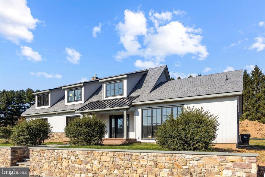 Nestled in the heart of the Jericho Mountain’s Conservation District, this one of a kind, Country Modern Estate is ready for the finishing touches. Included with the home, but ready for the buyer to choose, is the 20’x30’ swimming pool w/spa and patio and a 2-1/2 bay garage. (Both shown in the renderings). 
The brand-new septic system is approved for five bedrooms, so there is an option to have a one-bedroom living space above for guests or domestic help.  Surrounded by and overlooking hundreds of acers of preserved Bucks County farmland and rolling hills, this 4200 square-foot, modern masterpiece has all the traditional lines and elements of a classic Cape Cod estate.  After years of thoughtful planning by the late Jim Hamilton and the long-time property owners, architect Ralph Fey and his talented team, including neighbor Ben Phillips, made dreams a reality. The main level features approximately 3000 square feet of one-story living space, including a generous primary suite and a large laundry room. The second level adds another primary suite, two more bedrooms with a Jack and Jill bath and a second laundry room.
The expansive and impressive landscape plan is the work of internationally renowned designer and family friend, Renny Reynolds. His inspiration included recent trips touring extraordinary gardens on the north of France. Blue Raccoon owner, Nelson Zayes and Charles Weiler Kitchens and baths are heading up the interior style and selection process.  Steve king, of Kings Home Improvements in Lancaster Pa, is meticulously crafting the construction process, backed by generations of Amish craftsmanship. Watching them all collaborate was like listening to Pavarotti sing the opera. Agent is related to the seller.