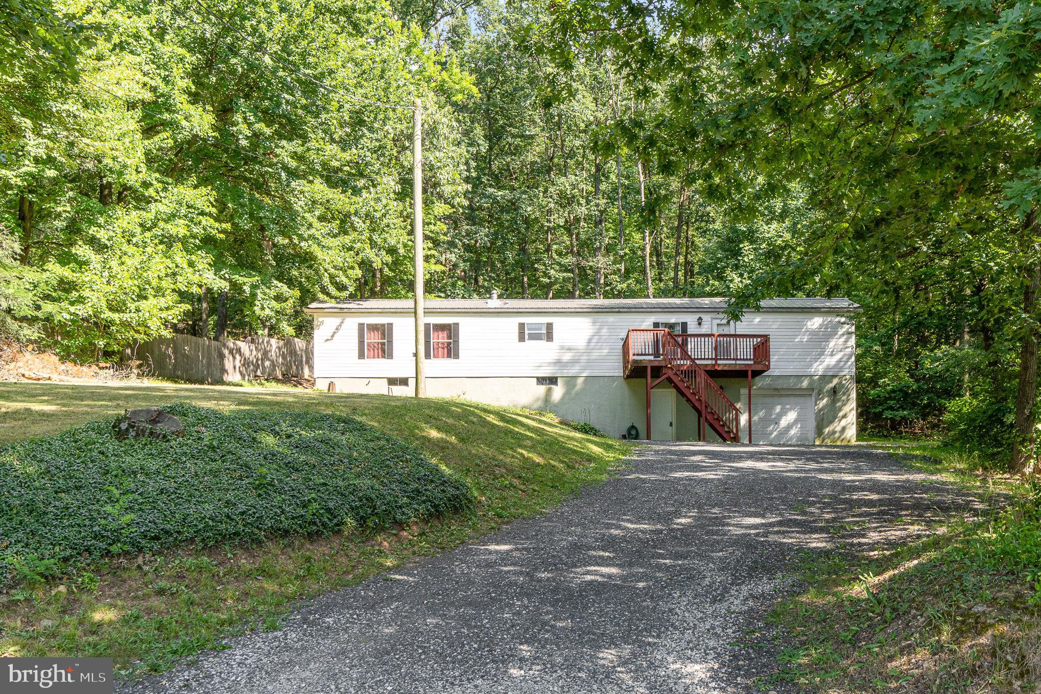Great mobile home on a permanent foundation in a great setting surrounded by trees. Big front deck welcomes you home. Step into the living room which has lots of room for furniture and it's open to eat in kitchen which includes all of the appliances. 1st floor laundry is an added convenience. The owner's suite has a walk in closet and double doors into the ensuite bathroom with double sink and tub. The 2nd bedroom also has it's own private full bath as well. The basement gives you tons of storage and access to the oversized built-in 1 car garage. Out back there is another deck and the yard is backed by trees. Located close to Lincoln Speedway, within a 5 min walk, makes going to the racetrack even more fun because you don't have to deal with parking your car. This great home won't last long!