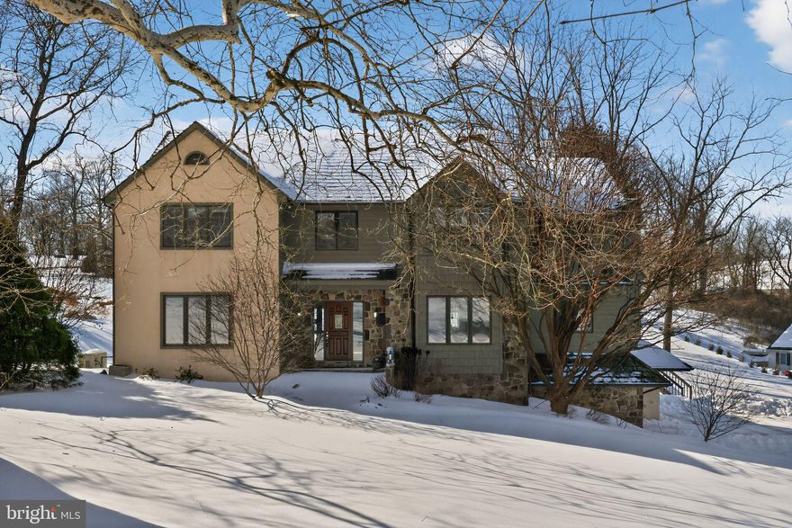 Welcome to 203 Barn Hill Road – Where Timeless Elegance Meets Everyday Comfort

Nestled in the sought-after and prestigious Blue Rock Meadows community, just minutes from the heart of historic West Chester Borough, this exceptional custom-built four-bedroom, 2.5-bath residence offers the rare blend of privacy, convenience, and unparalleled livability. Set on a beautifully landscaped one-acre lot in scenic East Bradford Township, the home is a private retreat designed for both quiet relaxation and gracious entertaining.

From the moment you arrive, the curb appeal is undeniable. A handsome stone and clapboard exterior, cedar shake roof, and a gently curving drive with ample guest parking set the tone for what’s to come. The attached three-car garage provides effortless entry and convenience, while a classic formal walkway welcomes you into the front foyer.

Inside, the home’s warmth and craftsmanship shine. Soaring cathedral ceilings, operable skylights, hardwood floors, and a stunning raised-hearth fireplace create a sense of airiness and comfort in the living room, where natural light pours through oversized windows framing serene backyard views.

To the left, a spacious home office with built-in shelving provides the perfect environment for remote work or study. A flexible den nearby offers endless possibilities—it has served as a music studio, exercise room, second office, and media lounge, adapting seamlessly to any lifestyle.

To the right of the foyer, a formal dining room with box-bay window and hardwood floors is perfectly sized for hosting holiday dinners and celebrations. The adjacent updated kitchen is a true showstopper, outfitted with abundant white cabinetry, a large center island, a newer refrigerator, and a massive walk-in pantry to keep everything beautifully organized. For the home chef, the gas range with downdraft vent makes cooking a joy—form and function in perfect harmony.

Open to the kitchen is the inviting breakfast room, where you can sip your morning coffee while overlooking the expansive deck and backyard. A cozy family room flows from the kitchen, featuring a second stone fireplace—ideal for relaxed evenings and casual get-togethers.

The main-level laundry room is generously sized with extra cabinetry for storage, and a well-placed powder room completes the first floor.

Upstairs, the primary suite is a private sanctuary. The spacious bedroom includes a charming window seat with hidden laundry chute, dual walk-in closets, and a spa-inspired ensuite bath with dual vanities, walk-in shower, soaking tub, tile flooring, and private water closet.

Three additional bedrooms—each with double closets—are located down the hall, along with a large hall bathroom featuring dual sinks and a tub/shower combination, perfect for guests or family.

The finished walk-out lower level adds tremendous value and flexibility, with a bright recreation room, a door to the patio and backyard, and interior access to the three-car garage. A separate finished room makes a perfect craft room, home gym, or second office, and there’s a large unfinished area for storage, complete with the home’s mechanical systems, whole house generator, and surge protection.

Step outside to your personal oasis. The backyard is a perfect mix of lush lawn and mature trees, creating a private, peaceful setting for outdoor dining, gardening, or play. The deck is ideal for entertaining, grilling, or simply unwinding while watching the sunset over your tranquil property.

Location is everything—and here, you truly have it all. Just minutes from vibrant downtown West Chester, enjoy a wealth of nearby restaurants, shops, parks, top-rated schools, and cultural attractions, all while savoring the peace and beauty of this premier neighborhood.

Whether you’re looking to entertain with style, relax in comfort, or enjoy the very best of Chester County living, 203 Barn Hill Road is a place to live, love, and truly call home.