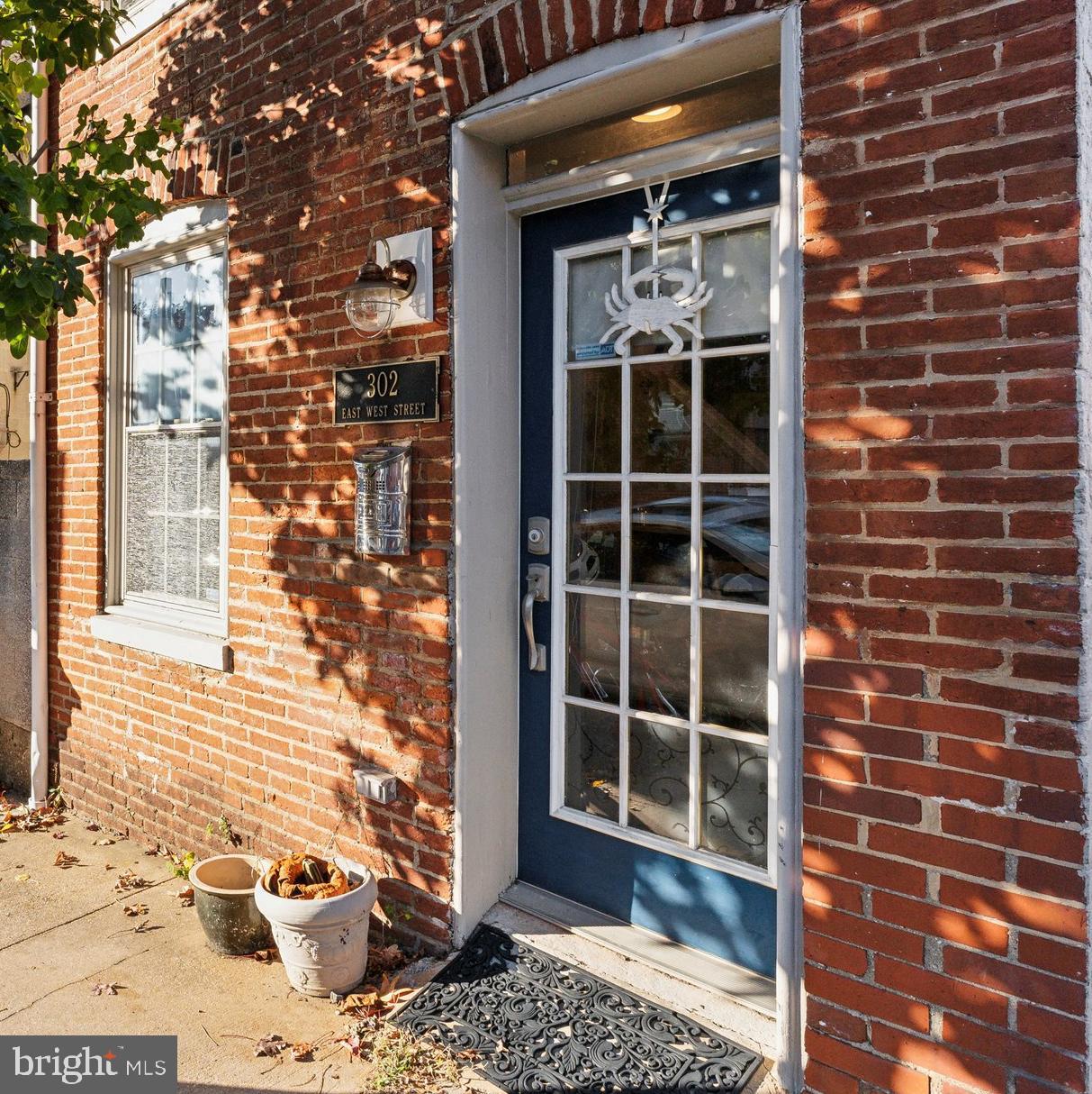 Welcome home to 302 E West St. This rare detached Federal Hill home exudes charm while having all the modern conveniences you are looking for in a property. As you enter into the cozy living room you are welcomed by the quintessential Baltimore exposed brick wall and beautiful wood floors (2021) that flow into the functional eat-in kitchen with stainless steel appliances, granite countertops, and plenty of cabinet space. Continue to the second level where there are two well-appointed bedrooms each with hardwood floors and a ceiling fan. There is a spacious full bath plus the washer and dryer (2021) that is also conveniently located on the second level. The third level includes a wet-bar and newer beverage refrigerator (2024) that leads out to the spacious roof-top deck that is perfect for entertaining or relaxing this summer. Enjoy peace of mind that that the roof and rooftop deck were recently replaced in 2023. The home also boasts one off-street parking spot that makes parking a breeze. Ideally situated, you are steps to Federal Hill Park, Cross-Street Market, and the Inner Harbor. Close proximity to the Stadiums and Downtown Baltimore. Easy access to I-95 and near to the Camden Train Station. Where historic charm meets convenience, you don't want to miss this one.