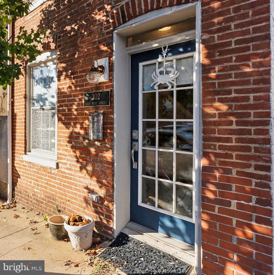Welcome home to 302 E West St.  This rare detached Federal Hill home exudes charm while having all the modern conveniences you are looking for in a property. As you enter into the cozy living room you are welcomed by the quintessential Baltimore exposed brick wall and beautiful wood floors (2021) that flow into the functional eat-in kitchen with stainless steel appliances, granite countertops, and plenty of cabinet space. Continue to the second level where there are two well-appointed bedrooms each with hardwood floors and a ceiling fan. There is a spacious full bath plus the washer and dryer (2021) that is also conveniently located on the second level. The third level includes a wet-bar and newer beverage refrigerator (2024) that leads out to the spacious roof-top deck that is perfect for entertaining or relaxing this summer. Enjoy peace of mind that that the roof and rooftop deck were recently replaced in 2023. The home also boasts one off-street parking spot that makes parking a breeze. Ideally situated, you are steps to Federal Hill Park, Cross-Street Market, and the Inner Harbor. Close proximity to the Stadiums and Downtown Baltimore. Easy access to I-95 and near to the Camden Train Station. Where historic charm meets convenience, you don't want to miss this one.