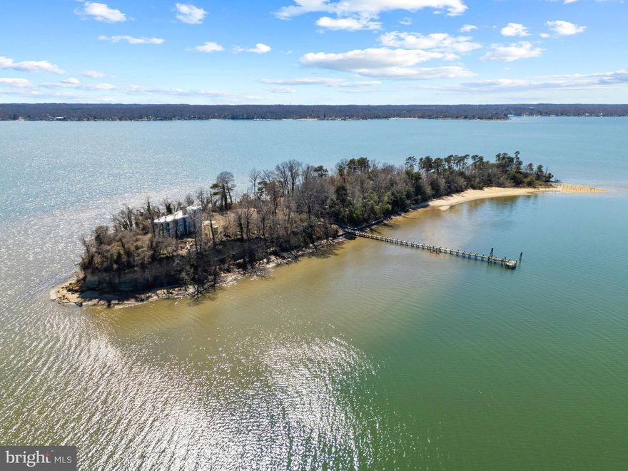 DOBBINS ISLAND!  Discover a once in a lifetime opportunity to own a private island retreat in the heart of the Chesapeake Bay region. The Magothy River's renowned Dobbins Island is a breathtaking 7.2 acre waterfront sanctuary, offering unmatched seclusion and stunning natural beauty. Accessible only by boat and just minutes from the mainland, this exclusive property is designed for those who seek a truly unique waterfront lifestyle. The newly constructed (2019), 4,000+ sq. ft. custom home features 3 bedrooms and 3 baths, complete with an elevator. It is thoughtfully crafted to highlight its spectacular 360 degree water views, extending from the Magothy River to the Chesapeake Bay Bridge. With a gourmet kitchen, multiple living spaces with fireplaces, soaring 10 foot ceilings, expansive windows, and ultra luxe finishes, the home seamlessly combines coastal elegance with modern luxury. The elevator provides easy access to every level, while various balconies and a rooftop deck create ideal spaces for soaking in sunrises, sunsets, and stargazing over the river. Outdoor living is truly exceptional, boasting over 4,000 feet of pristine water frontage, a private deep water dock with 8’ MLW for large boats, and a crescent shaped sandy beach perfect for swimming and sunbathing. A winding trail traverses the island’s scenic wooded ridges, where wildlife sighting... including ospreys, herons, and even a resident bald eagle, are part of everyday life. For added convenience, the property includes a dedicated private dock and parking on the mainland, ensuring seamless access to your island escape. An optional 2.5 acre waterfront parcel in North Beach is also available, presenting an opportunity to build an additional estate or guest retreat. Whether you’re fishing off the dock, sipping a glass of wine on the rooftop deck, or hosting unforgettable gatherings under the stars, Dobbins Island represents a once in a lifetime chance to own a legacy property that embodies the ultimate escape for enjoying waterfront living at its finest. Welcome Home!
