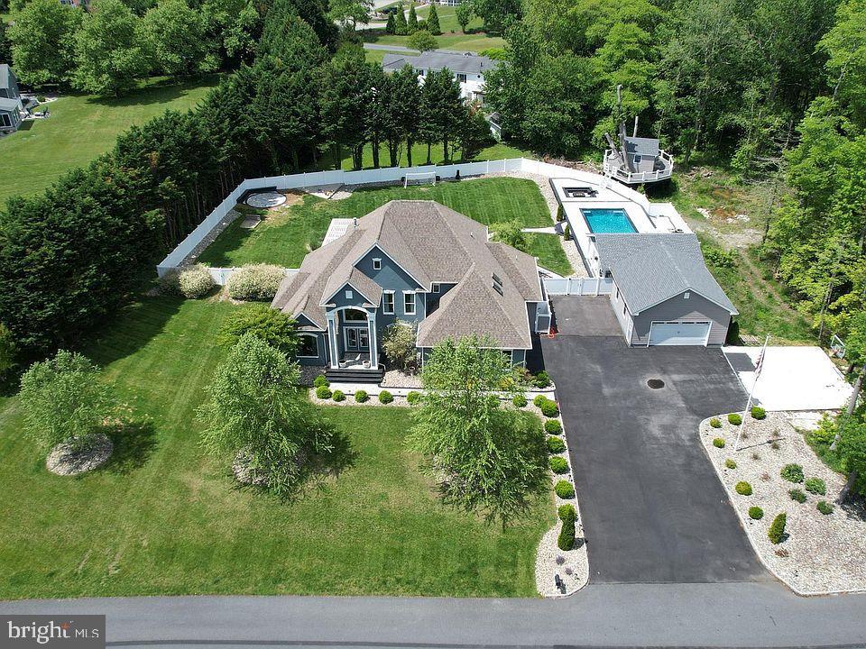 Welcome to 9 Greystone Drive located in Lewes Delaware just a short drive to the Beaches, Dining, Shopping, Bike trails and so much more. This home is situated on 1.5 beautiful acres with mature trees and privacy. The backyard is a resort feel with an in ground heated pool, a lounge shelf, fountains and a large covered cabana with an outdoor kitchen and eating area. There is a fire pit built in and the kids will love the huge tree house to hangout in. The home is a large 3500 Sq Ft with 4 bedrooms, 3 full baths, a flex room, a bright and sunny sunroom overlooking a large deck with an outdoor eating area and a huge hot tub built in the deck. The kitchen is a cooks dream. Installed in 2021, it has stainless steel appliances, Grante countertops, Center island with a farm style sink. A large pantry and built-in breakfast nook. There are 2 main bedrooms on the first floor and 2 bedrooms, full bath and a loft on the 2nd floor. The attached garage has heat and air conditioning, The new detached garage has heat and air conditioning and a upstairs for tons of storage. A car lover's dream. The crawl space was encapsulated in 2021. The family room is 2 stories with a stone gas fireplace for those chilly nights. All bathrooms were updated in 2023 and 2024. There is NOTHING you need to do other then move in and enjoy this resort style home.
