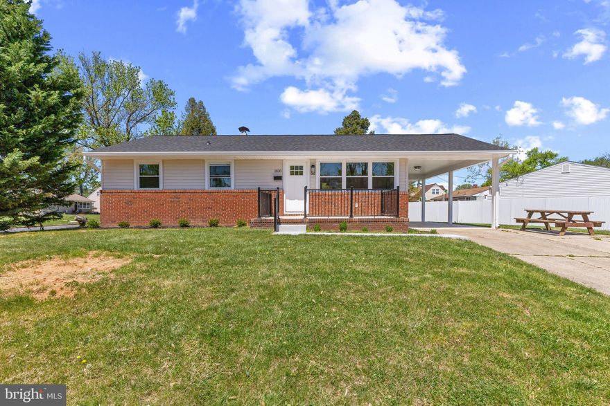 Completely renovated brick-accented conventional ranch-style residence offering 4 bedrooms, 2 bathrooms, 1,920 square feet, and a carport in charming Harundale. // A welcoming front porch invites you into a bright, open-concept main level featuring a sun-filled living room and an adjacent dining area highlighted by a timeless chandelier and easy access to the carport. // The beautifully updated eat-in kitchen is both stylish and functional, showcasing ceiling-height gray shaker-style cabinetry with elegant brass hardware, stainless steel appliances, quartz countertops, and a center island with breakfast bar seating illuminated by pendant lighting. // Down the hall, you’ll find a stunning, spa-inspired full bathroom with designer tilework, along with two generously sized bedrooms, including a comfortable primary with double closets. // The expansive lower level offers a large, open recreation room ideal for entertaining, another full bathroom, a versatile bonus space perfect for a home office or gym, a third bedroom with built-in shelving, and a fourth bedroom with walk-up exterior access—ideal for guests or flexible living arrangements. // Outside, the flat backyard provides a peaceful setting with a mature tree, partial fencing, and a storage shed, offering both functionality and outdoor enjoyment.