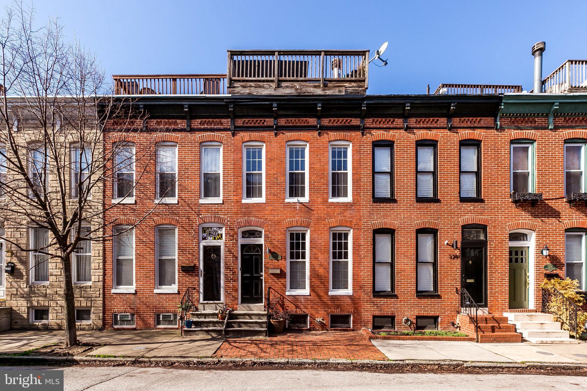 Amazing Federal Hill location! Extremely spacious 2 bedroom, 2.5 bath row home with PARKING PAD! ****This house is expansive... living room with wood burning fireplace, formal dining room that opens to the kitchen. Kitchen features tin ceiling and island with cooktop. Mud room with laundry and a separate half bath round out the first level. Master bedroom easily fits a king size bed! Access to roof top deck from main 2nd level hall so you don't have to walk through any bedrooms to get outside to see the incredible city views! Two fully renovated bathrooms on 2nd level.******** Features: hardwood floors, exposed brick, wood burning fireplace, tin ceiling, roof deck, main level laundry, PARKING.