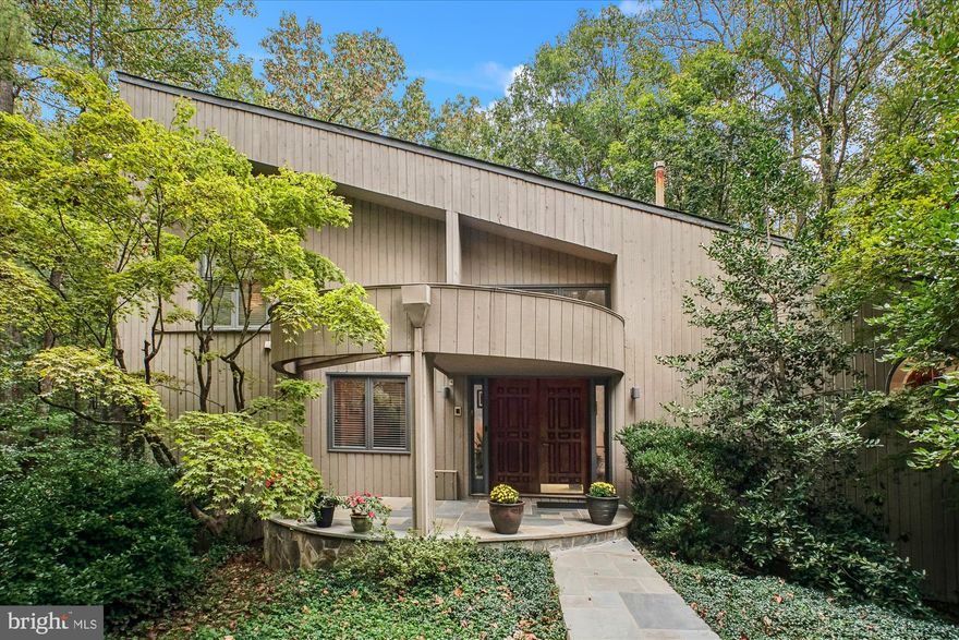 NESTLED AMONG MATURE TREES ON A BEAUTIFULLY LANDSCAPED CORNER LOT, THIS LOVINGLY MAINTAINED CONTEMPORARY GEM IS SURE TO IMPRESS. FOLLOW THE FLAGSTONE WALKWAY TO THE DOUBLE WOOD FRONT DOORS AND STEP INSIDE, WHERE TILE FLOORS AND DRAMATIC ARCHITECTURE SET THE STAGE. SOARING CEILINGS WITH EXPOSED BEAMS AND PILLARS CREATE AN OPEN AND AIRY FEEL, WHILE HARDWOOD FLOORS FLOW THROUGH THE FORMAL DINING ROOM WITH SKYLIGHTS AND INTO THE LIVING ROOM. HERE, A TWO-SIDED WOOD-BURNING FIREPLACE PROVIDES WARMTH AND AMBIANCE, COMPLEMENTED BY A STRIKING PALLADIAN WINDOW AND SLIDING GLASS DOORS THAT LEAD TO A CUSTOM TREX DECK. JUST OFF THE LIVING ROOM, A WET BAR AREA OFFERS THE PERFECT SPACE FOR ENTERTAINING.  THE GOURMET EAT-IN KITCHEN FEATURES HARDWOOD FLOORS, ABUNDANT CABINETRY, A DESK AREA, AND A CUSTOM WINE RACK, ALL ILLUMINATED BY ADDITIONAL SKYLIGHTS. FROM HERE, STEP INTO THE SCREENED-IN PORCH WITH A VAULTED CEILING, SKYLIGHTS, AND CEILING FAN—A WONDERFUL RETREAT FOR DINING OR SIMPLY ENJOYING NATURE, WITH DIRECT ACCESS TO THE DECK.  UPSTAIRS, THE PRIMARY SUITE IS A PRIVATE HAVEN WITH ITS OWN WOOD-BURNING FIREPLACE, CUSTOM SHUTTERS, AND SLIDING GLASS DOORS TO A PRIVATE TREX DECK—THE PERFECT SPOT FOR MORNING COFFEE. THE SUITE ALSO OFFERS TWO WALK-IN CLOSETS, AN ADDITIONAL CLOSET, AND AN ATTACHED FULL BATH WITH A STAND-ALONE SHOWER AND SOAKING TUB. ASCEND THE SPIRAL STAIRCASE TO A LOFT AREA, IDEAL FOR A HOME OFFICE, LIBRARY, OR HOBBIES.  THE LOWER LEVEL FEATURES TILE FLOORING, A PRIVATE ENTRY FROM THE DRIVEWAY, AND ACCESS TO THE TWO-CAR GARAGE WITH WORKSHOP AREA. THREE GENEROUSLY SIZED BEDROOMS WITH NEUTRAL CARPETING, TWO FULL BATHS WITH TUB/SHOWER COMBOS, A LAUNDRY ROOM WITH WASHER, DRYER, UTILITY SINK, AND SHELVING, PLUS A MASSIVE WALK-IN STORAGE AREA COMPLETE THIS LEVEL.  FILLED WITH NATURAL LIGHT YET SURROUNDED BY TREES, THIS HOME OFFERS THE PERFECT BLEND OF MODERN DESIGN AND NATURAL BEAUTY—TRULY A UNIQUE FIND. SOME IMPROVEMENTS/UPDATES INCLUDE: ROOF (2024), FURNACE REPLACED (2023), NEW KITCHEN WINDOW & PORCH SLIDING GLASS DOOR, PRIMARY BEDROOM TOILET (2022), TREX ON BOTH DECKS, NEW PRIMARY BEDROOM SLIDING GLASS DOOR TO DECK (2020), SCREENED IN PORCH, ONE SET OF WINDOWS IN A BEDROOM DOWNSTAIRS, 3 NEW SLIDING GLASS DOORS IN LIVING ROOM AND DINING ROOM (2019), ONE AC UNIT REPLACED (2017)