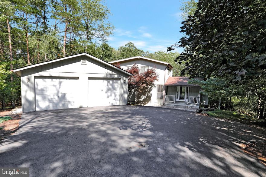 Located in The Woods Resort community is this popular Elmwood Model with modifications.  There is a large Living and Dining Room with hardwood floors, vaulted ceiling, and loads of natural light.  Family Rroom has 2-story ceiling with the wall of windows.  There is a main level bedroom with full bath.  Two bedrooms upstairs, one is a loft, with joined by a full bath and walk-in closet.  The back features a 11x17 deck with large lower tier and hot tub.  There are benches and and awning to enjoy your outdoor space.  Privacy and nature abound in this beautiful oasis.  There is a convenient breezeway to the two car garage.  Private wooded setting.  Class A Membership Available.