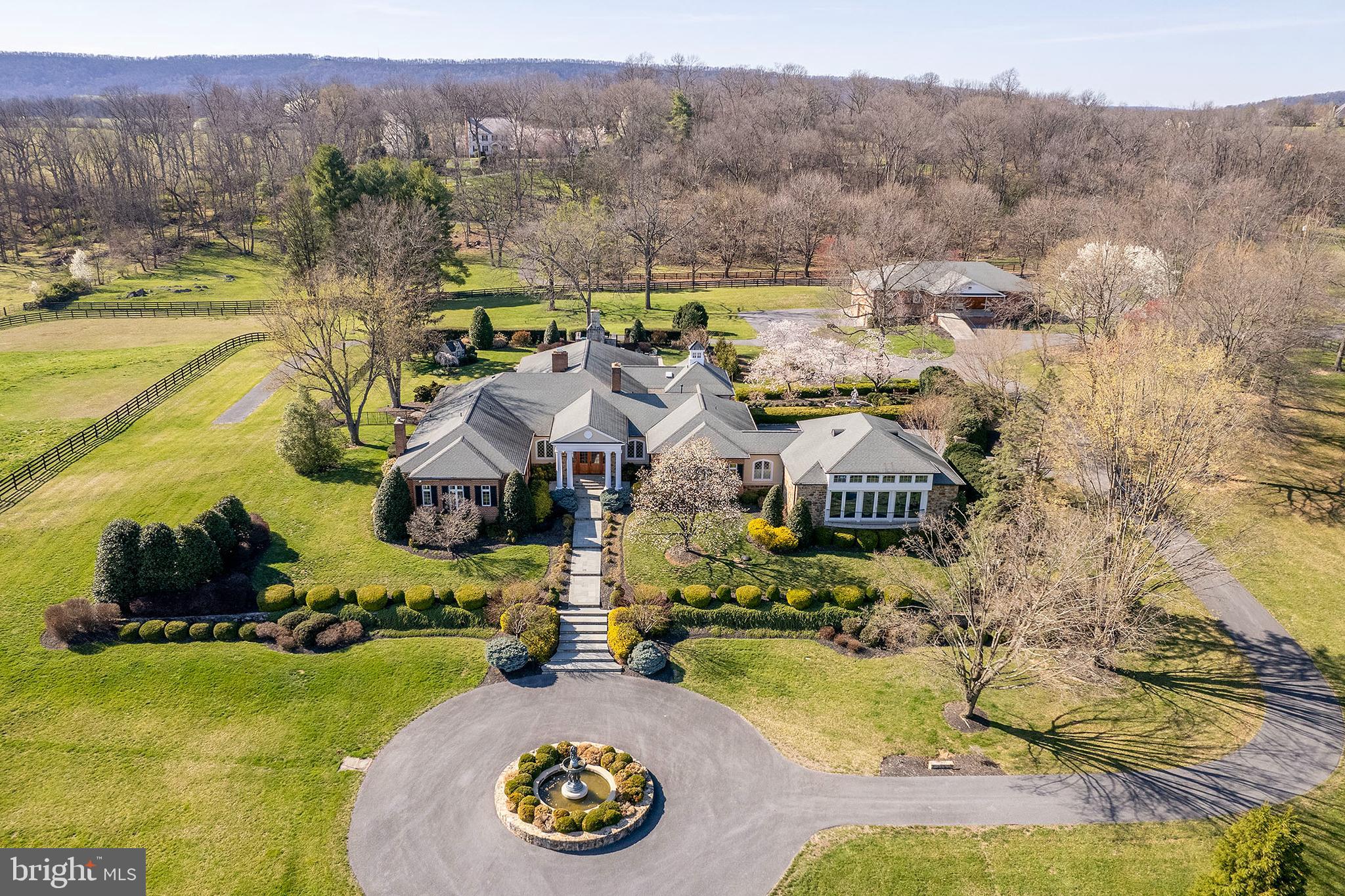 Designed for living and entertaining on a grand scale, this estate is a testament to fine architecture and quality craftmanship. The elegant foyer is a prelude to the resort-inspired recreation room, pool and professional gym, loaded with amenities. 15-plus acres of professional landscaping as well as a brick stable with additional parking and storage, plus verdant paddocks. A unique venue to escape the world or invite it in to share the experience.