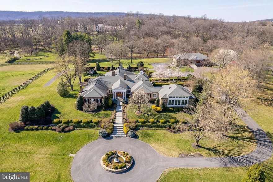 Designed for living and entertaining on a grand scale, this estate is a testament to fine architecture and quality craftmanship. The elegant foyer is a prelude to the resort-inspired recreation room, pool and professional gym, loaded with amenities.  15-plus acres of professional landscaping  as well as a brick stable with additional parking and storage, plus verdant paddocks. A unique venue to escape the world or invite it in to share the experience.