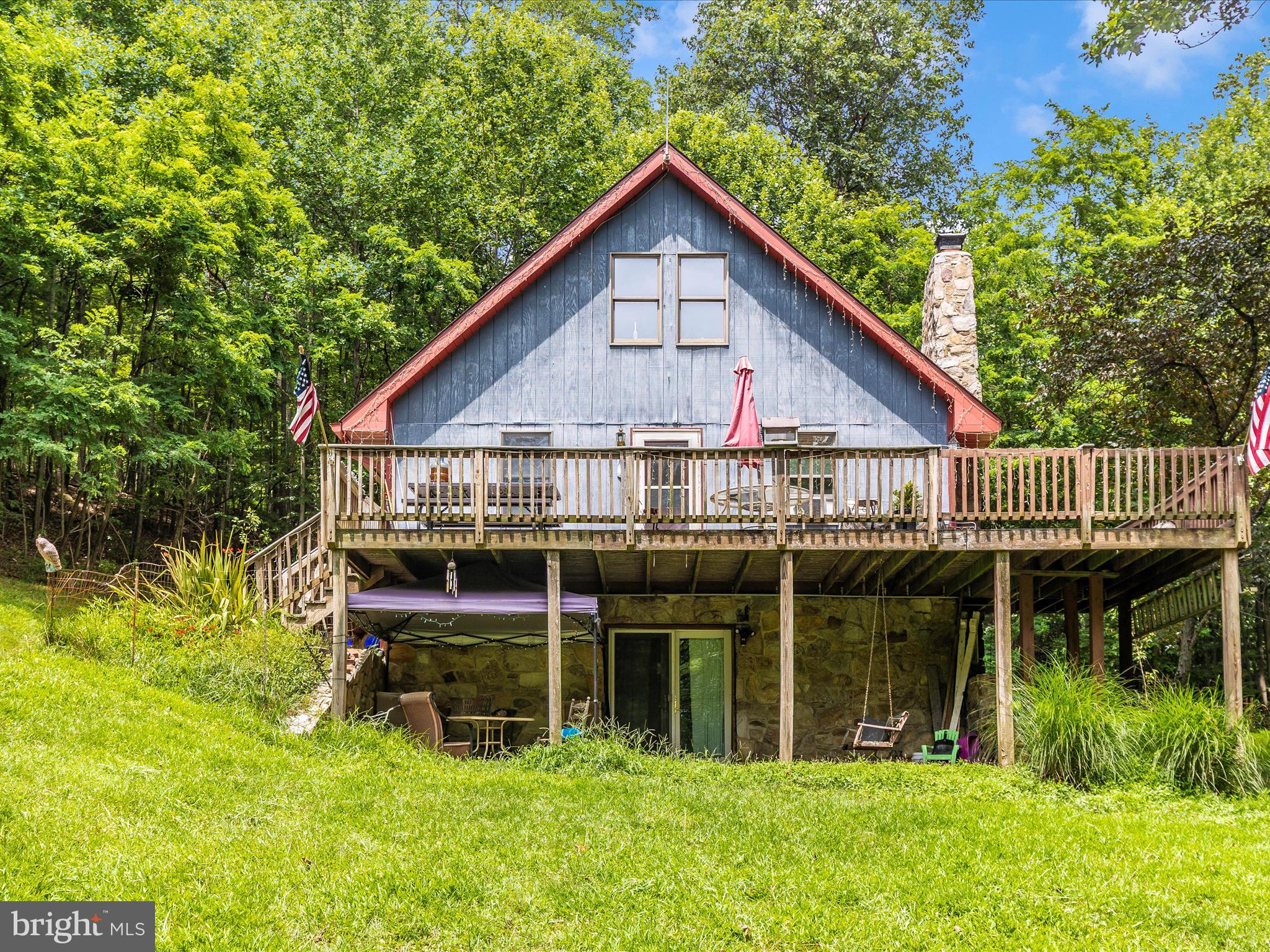 Escape to your own private retreat at 11220 C Putman Rd, a peaceful 9.87-acre wooded property just minutes from Route 15. Surrounded by nature, this charming A-frame home offers rustic character and the perfect setting for enjoying the outdoors. Step inside to a warm and inviting living room with vaulted ceilings, wood floors, and a cozy woodstove set in a stone surround. The main level includes a cozy kitchen, full bath, and a bedroom. Upstairs, offers a loft-style second bedroom. The finished lower level features a spacious family room with a second woodstove, a full bath, and walkout access to the yard—ideal for relaxing or entertaining. Enjoy the sights and sounds of nature from the large deck, perfect for morning coffee, evening gatherings, or simply taking in the peaceful wooded surroundings. Additional features include an updated roof in 2023, detached outbuilding/garage and a shed with covered kennels—offering flexibility for hobbies, storage, or animals. Whether you're seeking a full-time home or a weekend getaway, this one-of-a-kind property delivers the tranquility of country living with the convenience of nearby commuter routes.