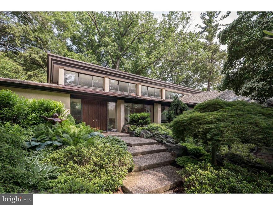 Welcome to this lifestyle home designed for family and entertaining that is situated on almost 2 acres of specimen plantings. Entering at the upper circular driveway, one sees a grand stucco, stone and glass house. On the grounds are an outdoor pool and two gazebos one of which has a full kitchen and gas grill for outdoor use and entertaining. Part of this house was built in 1928 as the carriage house to the Dannenbaum estate, all stone. Added to this is a wraparound contemporary addition designed by a noted architect, Irwin Stein. This section of the house includes an indoor pool area that has its own kitchen, changing area and full bath. The indoor pool area opens to a gracious brick patio with a built-in gas barbecue and serving ledge. A home that truly showcases nature with floor to ceiling glass windows throughout the back. The travertine entrance foyer leads into a sunken living room with fireplace. A dining room with built-ins, hardwood floors and accommodates up to 25 seated for dinner, a rounded kitchen with an eat-in area for 8 that connects to a family room with fireplace. The bedroom wing includes 2 large bedrooms with built-in closets, a full bath, laundry room, utility closet, side door entrance and library that can be converted to another bedroom, plus a master suite. The master suite has his and her dressing rooms, 1-1/2 baths, walk in closets, and a bathroom with windows that make the Jacuzzi bath seem like it is outside. From the Master Bath a staircase leads to the ground level with an exercise room, powder room, an area to be used for office or other, and a four car heated garage. Also from the Master Bedroom, doors lead to the indoor pool area. This house features lots of built-ins, vaulted ceilings and plenty of storage. A summer retreat and a winter fantasy. A must see. This sensuous home is extraordinary, waiting for the buyer who desires a fun, informal and gracious lifestyle.