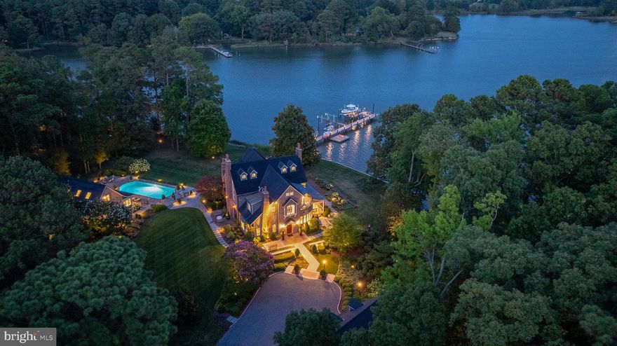 Welcome to your private oasis tucked away on ​​Sadlers Cove, leading to Broad Creek. This exquisite ​​French boasts over 700+/- feet of picturesque ​​waterfrontage, offering unparalleled water views ​​from nearly every point on the estate. The ​heart of ​the home is the fully updated kitchen, ​equipped with ​a 6-burner Wolf stove, two built-in Sub-Zero ​refrigerators, a wine cooler integrated into the island, ​and dual dishwashers, making it a chef’s dream. Adjacent to the kitchen, the living room features a gas fireplace, grand ceilings and access to the screened-in ​​side porch, where a wood-burning fireplace adds warmth and charm. The office/family room is flooded with ​​natural light and offers stunning water views, creating an ideal space for work or relaxation. The main level ​​features a luxurious en-suite bedroom with breathtaking ​waterfront views, that welcome the day with serene ​sunrises. ​ The majestic ​staircase leads to two additional en-suite bedrooms, each with its own balcony, offering ​fantastic views of the water. This ​home is equipped with state-of-the-art technology, including a Lutron lighting ​system, built-in stereo system, ​and an internet-connected appliances for ultimate convenience. The outdoor ​spaces are equally impressive. Meticulously maintained gardens and lush lawn are serviced by an advanced ​irrigation system. The gated vegetable garden is a green thumb's delight. The property puts on a nightly light ​show with its extensive outdoor lighting starting at the entrance to the property all the way to the lighted dock. ​The waterfront in-ground pool, outdoor kitchen, and the fully equipped pool house provide outdoor fun and ​relaxation as well as a wonderful separate and private place to host guests. The two-​story garage offers ​additional recreation space with two bars and a half bathroom.