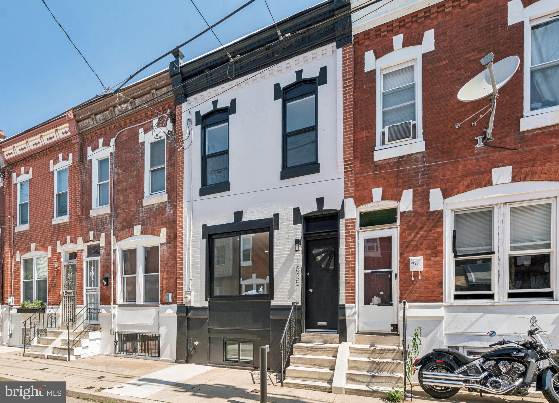 Classic Point Breeze rowhome leaves nothing for you to do except move in and take all the credit for this pristinely re-crafted home. Built in 1920 and given the gift of an incredible renovation for it's 105th birthday, this property was taken down to the studs and reassembled to last another 100 years on Dudley Street. This quiet, one way street is wide enough to allow an easy drive to your front door to drop off groceries before finding a convenient spot to park. You'll recognize 1835 right away with its crisp black and white exterior color scheme that draws the eye right to the refurbished Tofani front door. Any South Philly aficionado will recognize it as an iconic piece of their history. Originally manufactured here in the '20s, the doors are strongly associated with South Philly and give the home the authenticity it deserves. Inside, 1835 Dudley is so fresh and so clean. A full gut renovation was performed to reset the clock on this home. You'll find that the stylish minimalism allows the space to shine. Inspect every inch to see that the new drywall, electrical, plumbing, HVAC, roof, appliances, windows, cabinets, etc were crafted and installed to the highest standards. No corners were cut to bring a fully dry, finished basement that should withstand most any storm. You'll find 2 sump pumps, a french drain, and waterproofing on the walls and floors to keep your lower space ready for any party with a sink, cabinet and mini-fridge for drinks. On the main level, the modern transitional style kitchen has new 2-tone cabinets, quartz countertops and a herringbone tile backsplash. A breakfast bar is lit by modern glass teardrop pendants, and showcases all new appliances including a stainless steel Frigidaire dishwasher, microwave and range plus a Whirlpool refrigerator. A brand new powder room on the main level keeps guests from having to use the stairs just to use the potty. Upstairs, the hallway was widened for ease, and takes you between 3 bedrooms, a full bath, and the laundry closet where you'll find TWO LG combo washer/dryer machines. No waiting for the washer when you can just start a load in the other machine. Each bedroom has a ceiling fan with remote control, and the primary invites you in with a remote-controlled, color-changing electric fireplace, inset in the marble detail on the wall, with heat and cooling features. The only other place to check out now is the back of the house, off the kitchen. A new exterior door leads to a freshly poured concrete back patio, surrounded by a high wooden fence. Admire the new HVAC compressor out here that will bring you air conditioning colder than a lemon water ice from Chuck's Water Ice just a few blocks away. Thank you for coming to see if 1835 Dudley St can be your next home!