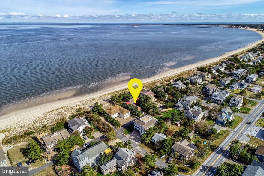 Rare opportunity to own a piece of history on Lewes Beach. This 1920's cottage is situated on an oversize 75' x 100' bay front parcel offering beach access and spectacular views. Located between Iowa and Missouri Avenues, enjoy the convenience of being just steps from the Lewes Yacht Club and marina.  Through the years, this cottage has gone through various renovations and offers 6 spacious bedrooms, 3.5 baths, and an oversized 2 car garage ideal for storage for your beach, fishing and sailing gear. The exposed beams, wood burning fireplace, and welcoming front porch are very charming. The views are spectacular from many of the bedrooms and living areas. This property has tremendous potential with improvements or start fresh and build your dream home overlooking the Delaware Bay. 2112 Bay Avenue is truly a treasure!