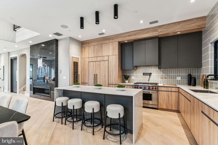 Rittenhouse Square new construction CORNER home in Albert M Greenfield School Catchment, fully loaded and now available! This exquisite residence is the only home in the development with a private side yard and rises 46 feet high, creating impressive ceiling heights throughout, including a breathtaking two-story living area. This corner home's side windows bring additional natural light to an already bright and cheerful layout.  Upon entering, you're welcomed by a stunning herringbone tile foyer, complete with custom millwork cabinetry perfect for storing shoes, coats, and other belongings. This level also offers access to the oversized two-car garage, which includes electric vehicle charging capabilities. The custom-designed staircase, featuring thick floating oak treads, leads to an expansive living space bathed in natural light throughout the day. The wide-plank herringbone flooring continues into the open living and dining areas, setting a tone of sophistication. The state-of-the-art chef’s kitchen is equipped with Sub-Zero and Wolf appliances, custom cabinetry designed for maximum storage, and a wet bar. The living room is perfect for entertaining or cozy nights in, with a large gas fireplace as the focal point. Adjacent to the kitchen is a generously sized patio, complete with a gas line for effortless outdoor grilling, and ideal for al fresco dining. On the third floor, you’ll find two spacious en-suite bedrooms, each with custom closets and beautifully appointed bathrooms. A full-sized laundry room with washer, dryer, and thoughtfully designed cabinetry is also located on this floor for ultimate convenience. The fourth floor is a true private retreat – an expansive primary bedroom suite with amazing views, a private balcony, a luxuriously outfitted walk-in closet, and a spa-inspired bathroom which features heated floors, a steam shower with multiple jets, and a serene ambiance, creating the perfect place to unwind. The top floor boasts an impressive roof deck designed for entertaining. This massive outdoor space is wired for TV and sound, and is even capable of accommodating a hot tub, making it the perfect place to relax while enjoying sweeping views of Rittenhouse Square as the day fades into night. Bowery Place also offers numerous additional luxury features, including a five-stop elevator, a full AV tech package, and much more. Expertly designed and brought to life by ZATOS Investments & Construction, this is truly a must-see property. Please note: Taxes are not $1. Buyers are responsible for verifying taxes and square footage. The homes come with a new tax abatement.